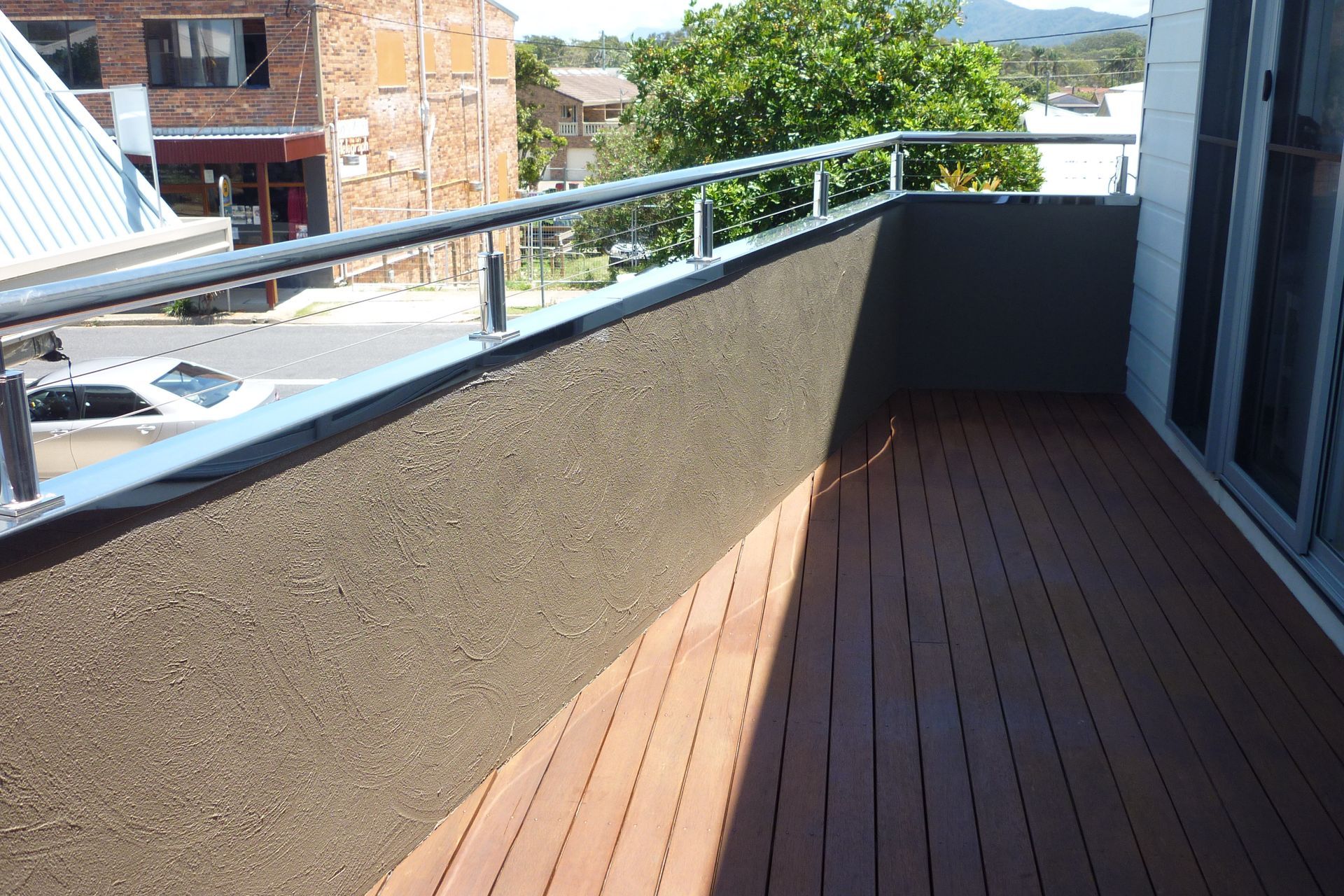 A balcony with a wooden deck and a metal railing — Fabricator In Coffs Harbour, NSW
