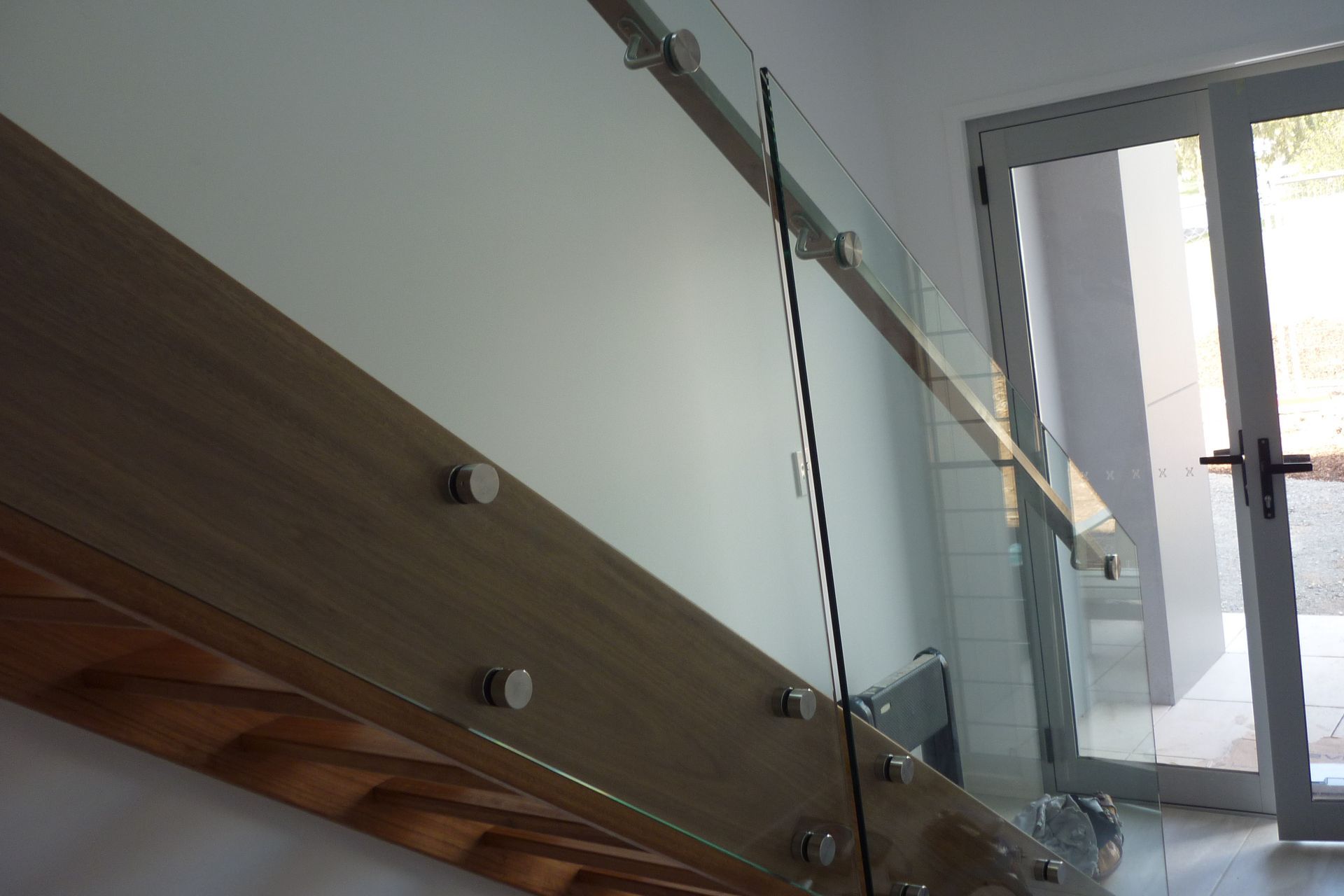 A staircase with a glass railing and a wooden handrail — Fabricator In Coffs Harbour, NSW