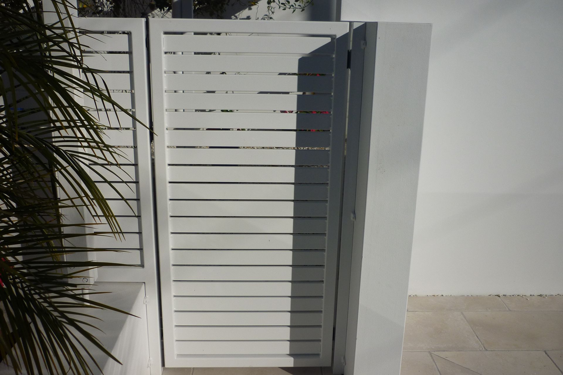 A white fence with a palm tree in the background — Fabricator In Coffs Harbour, NSW
