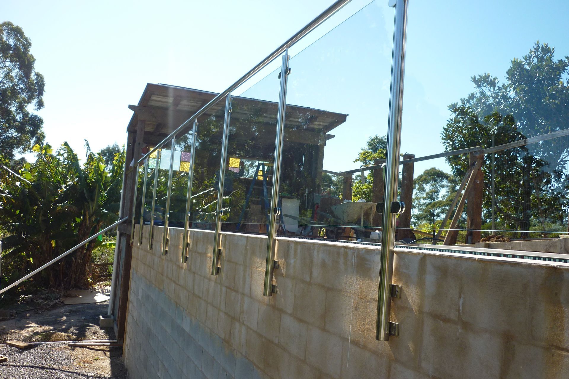A brick wall with a glass railing attached to it — Fabricator In Coffs Harbour, NSW