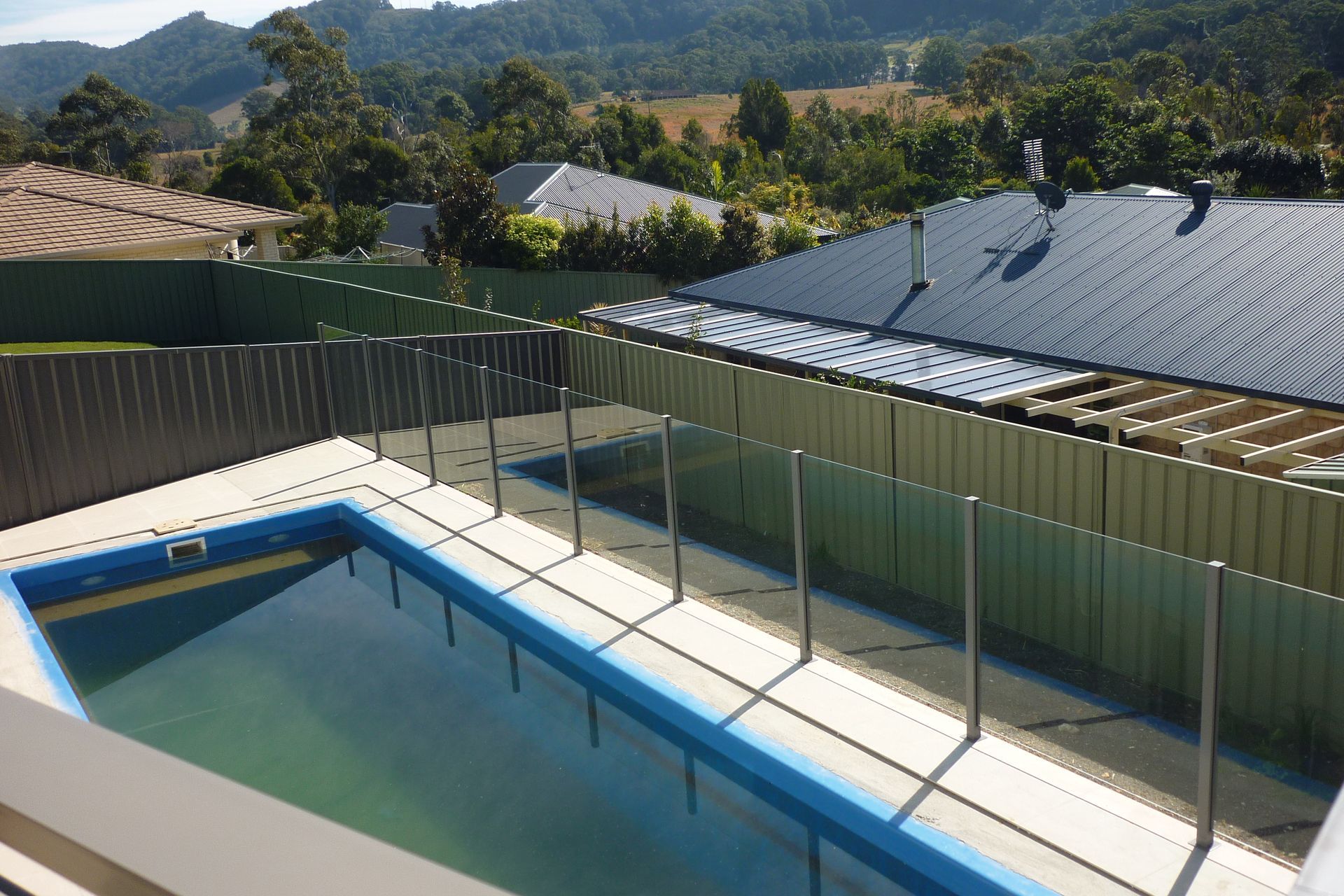 A large swimming pool with a fence around it — Fabricator In Coffs Harbour, NSW