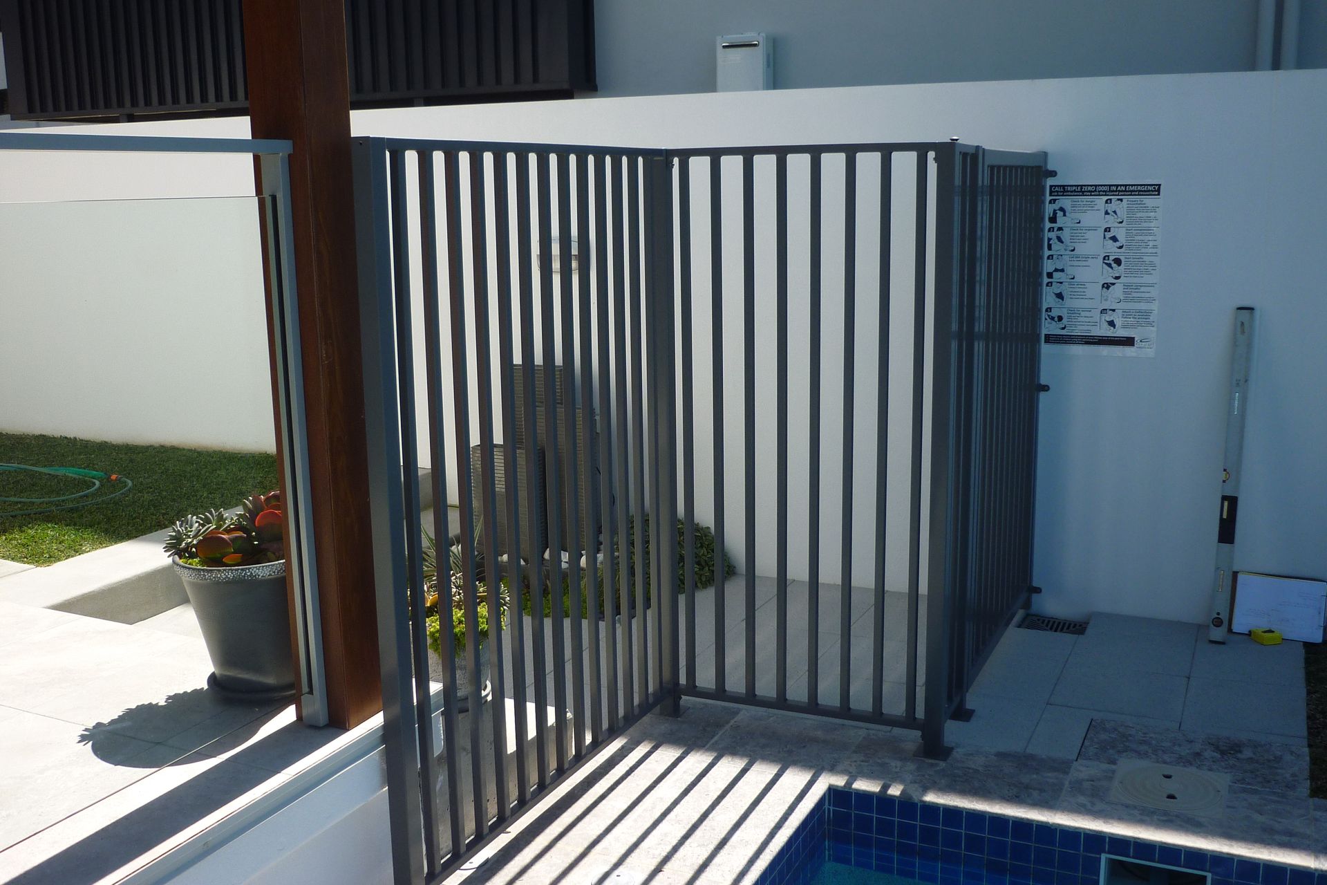 A metal fence surrounds a swimming pool in a backyard — Fabricator In Coffs Harbour, NSW