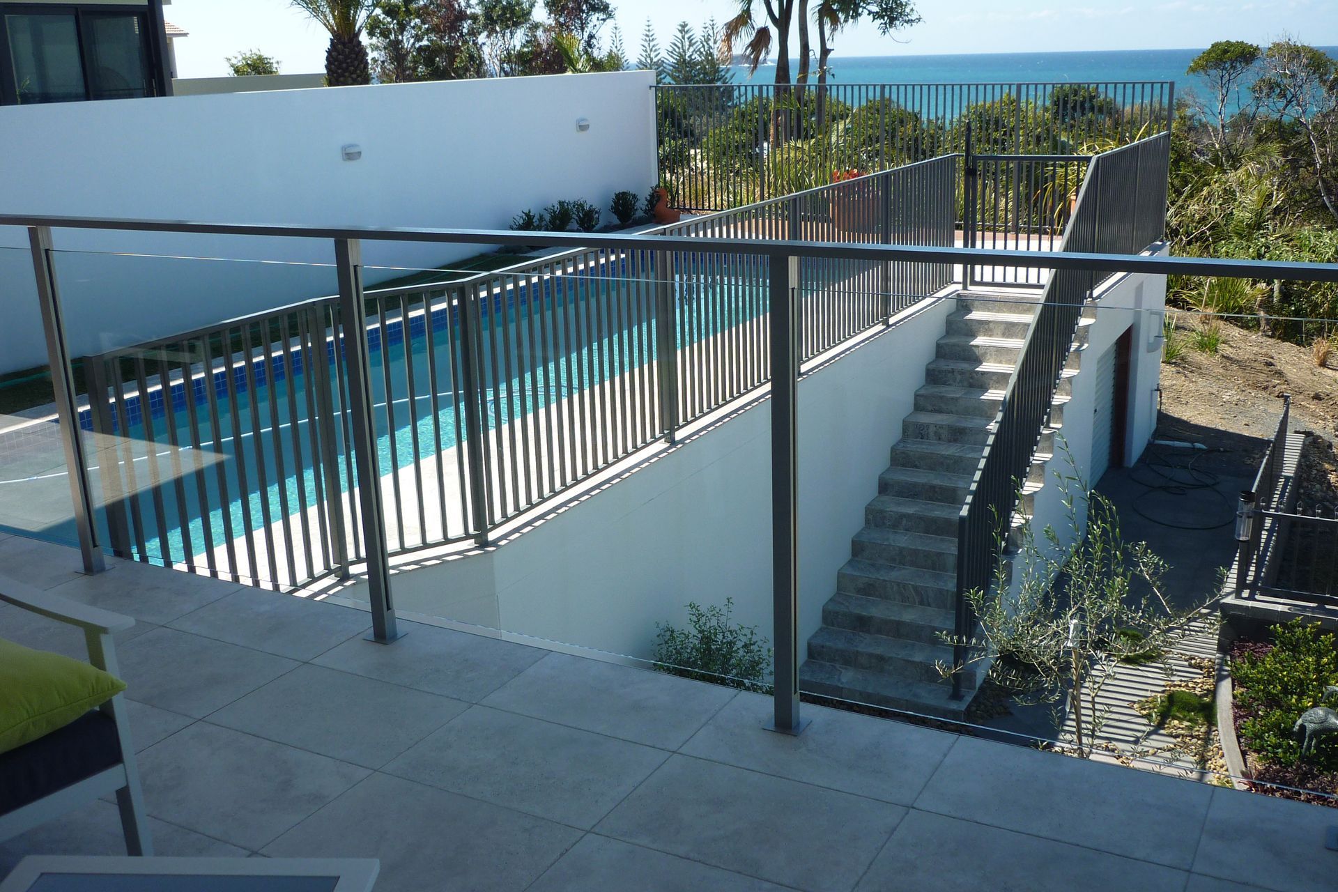 A balcony overlooking a swimming pool with stairs leading up to it — Fabricator In Coffs Harbour, NSW