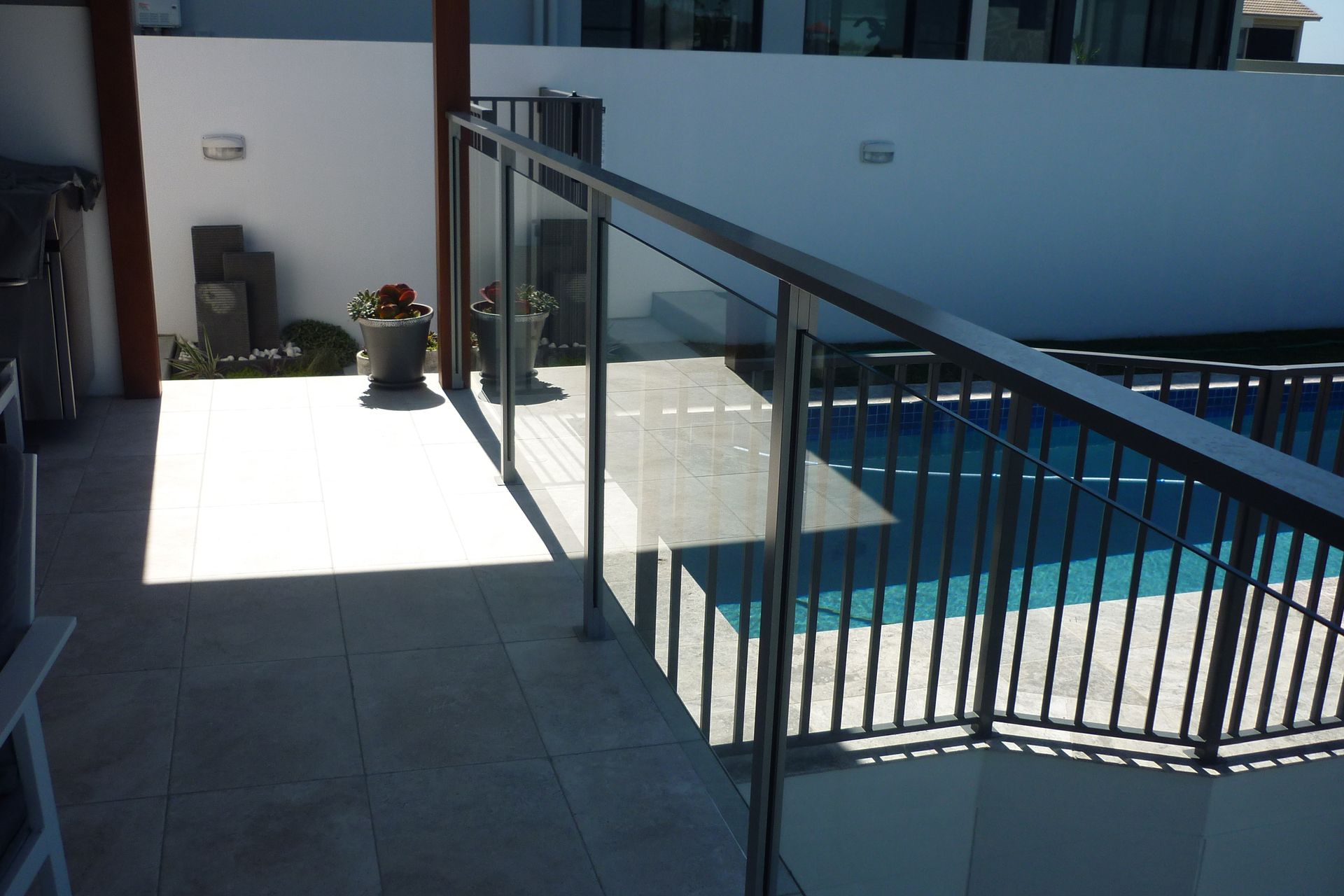 A staircase leading to a swimming pool with a glass railing — Fabricator In Coffs Harbour, NSW