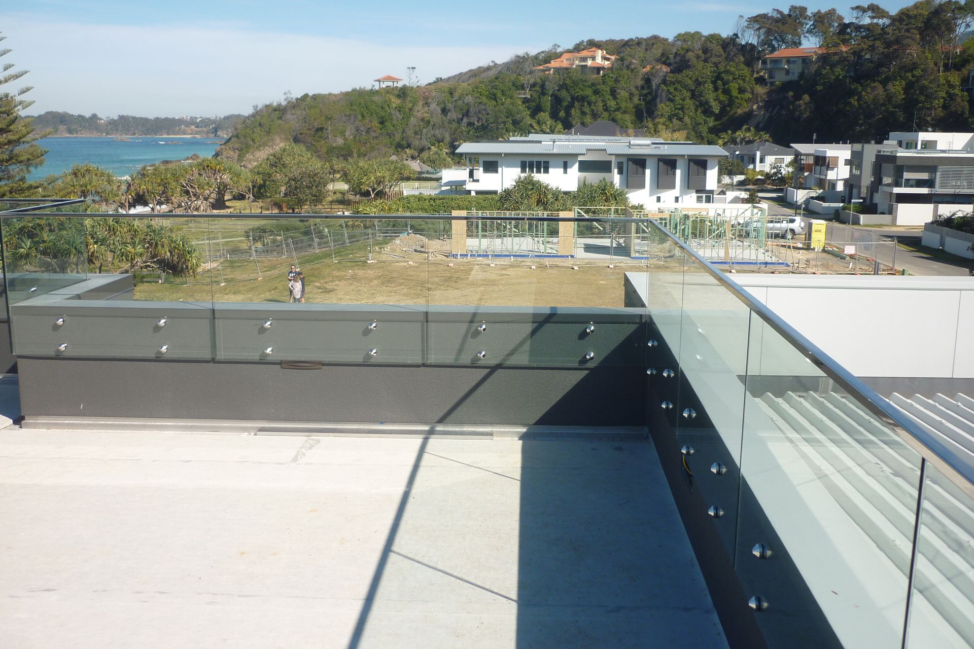 A view of the ocean from a balcony with a glass railing — Fabricator In Coffs Harbour, NSW