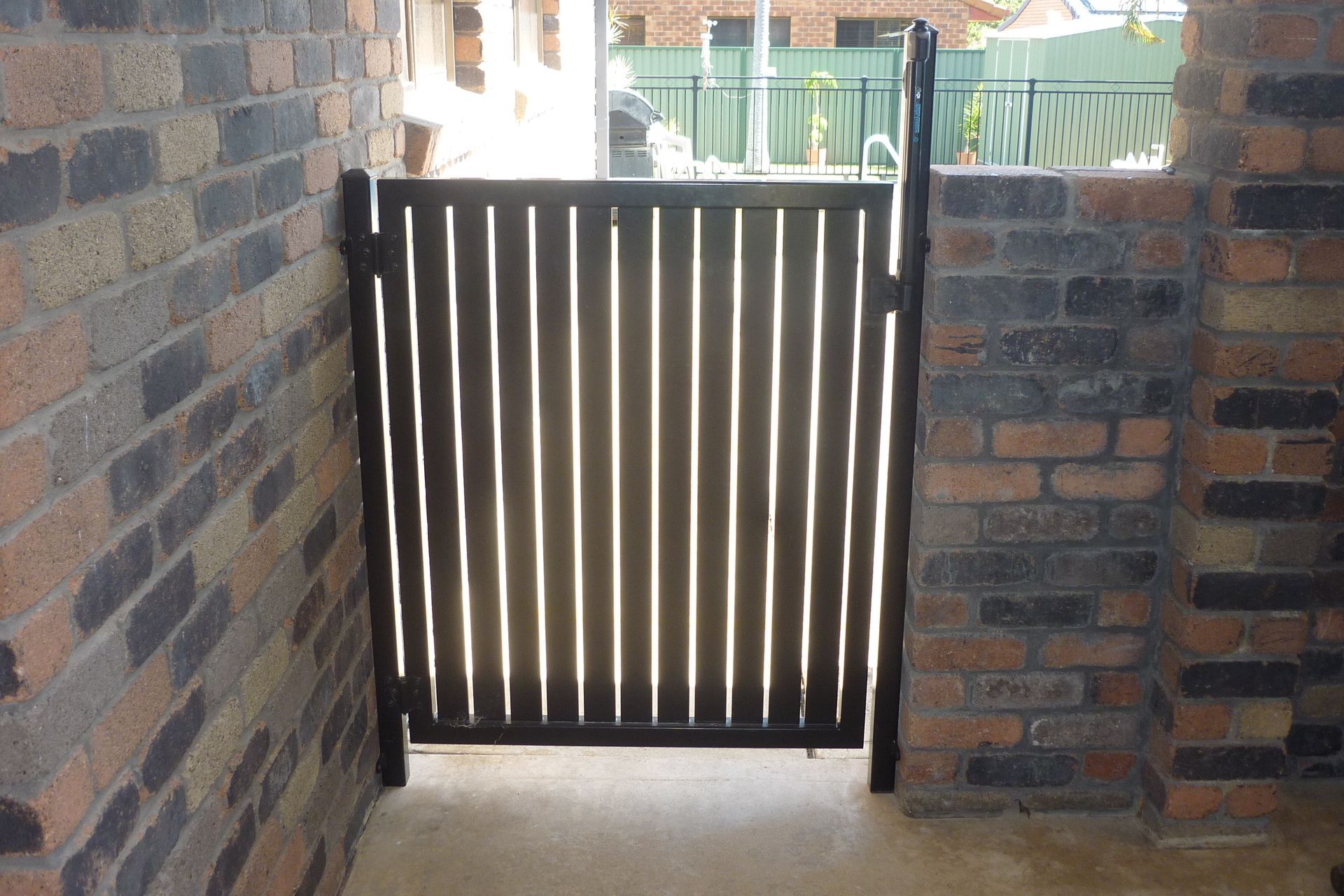 A brick wall with a gate in the middle of it — Fabricator In Coffs Harbour, NSW
