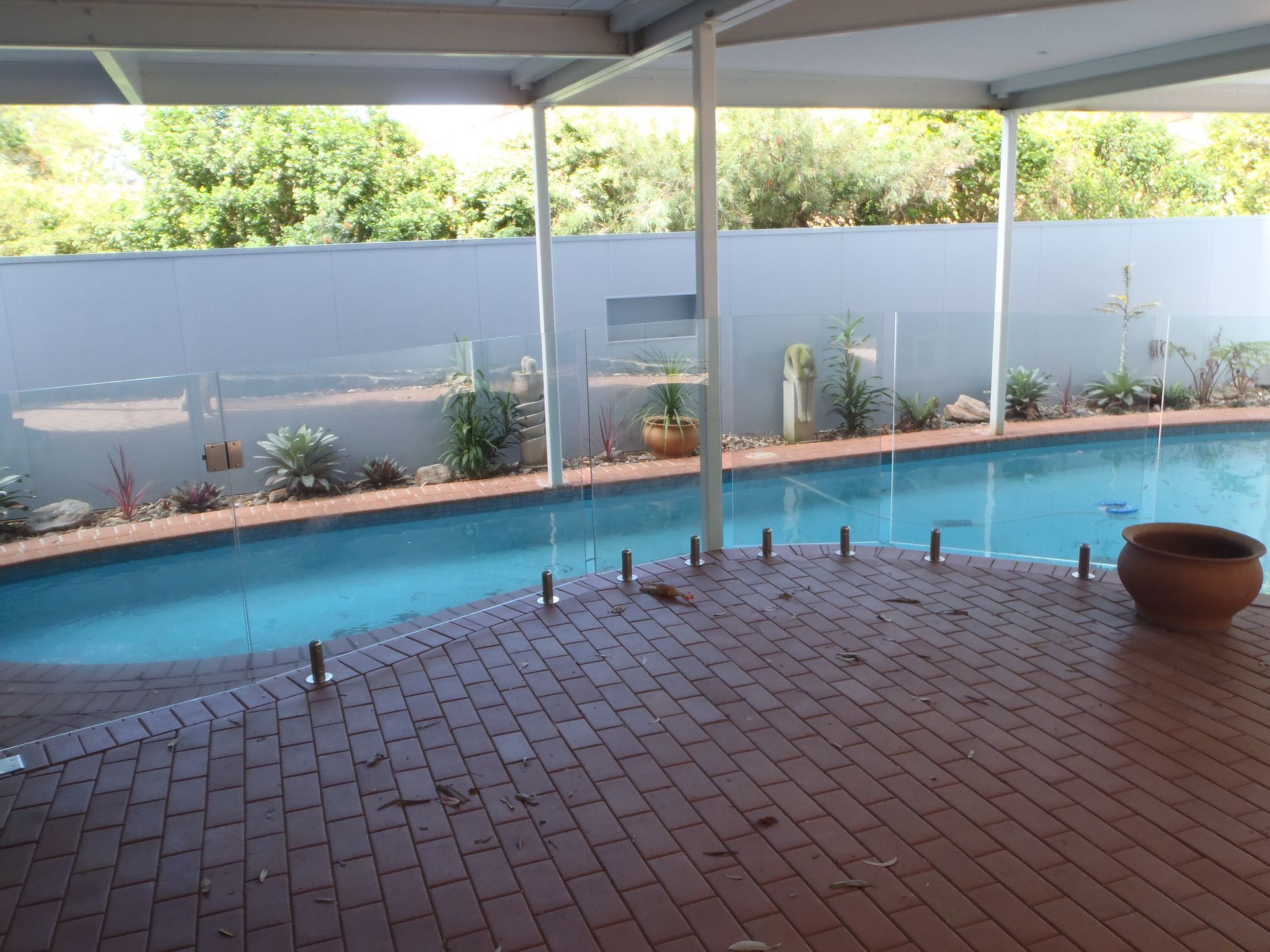 A large swimming pool with a glass fence around it — Fabricator In Coffs Harbour, NSW