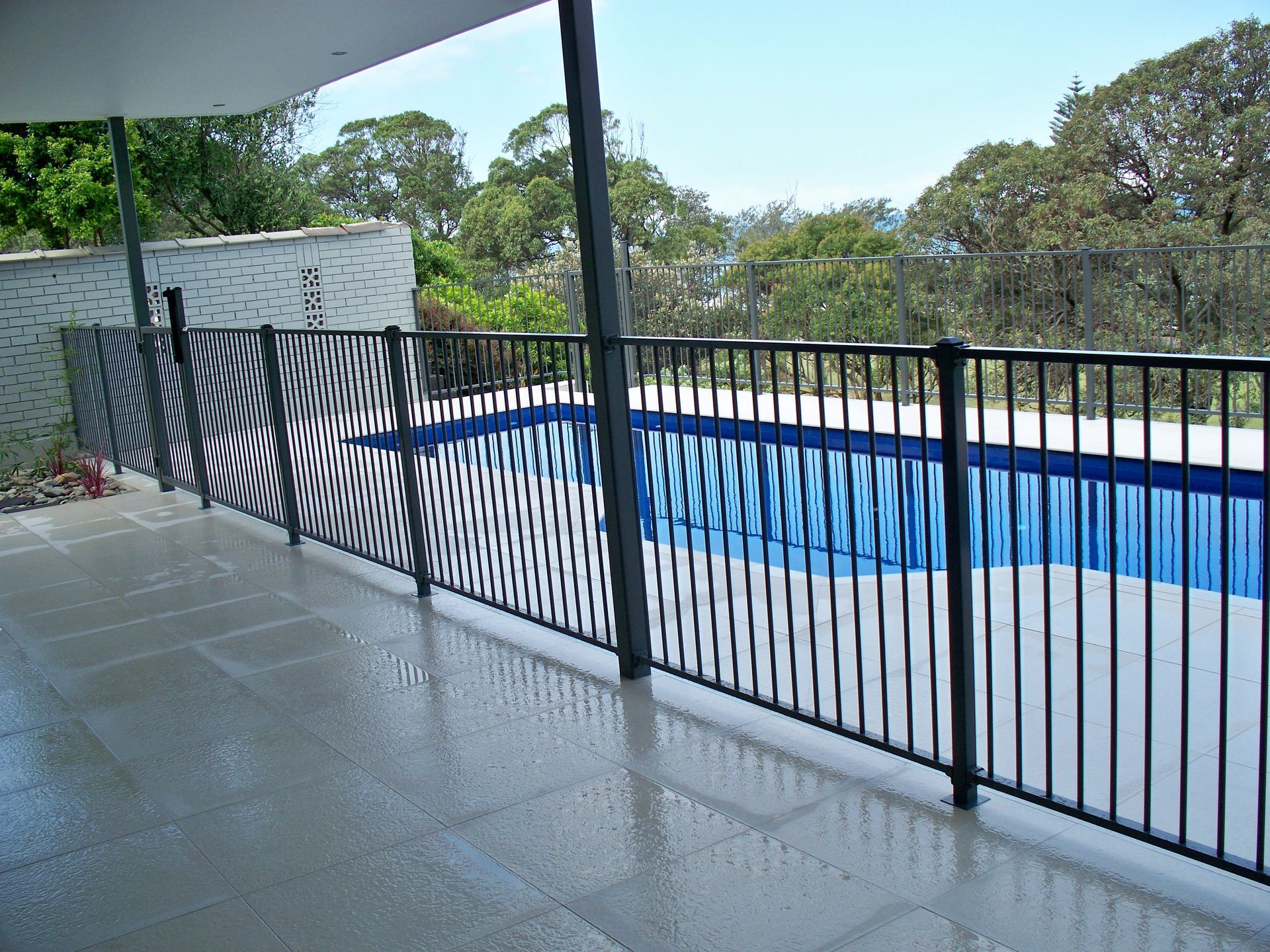 A balcony overlooking a swimming pool with a metal fence — Fabricator In Coffs Harbour, NSW