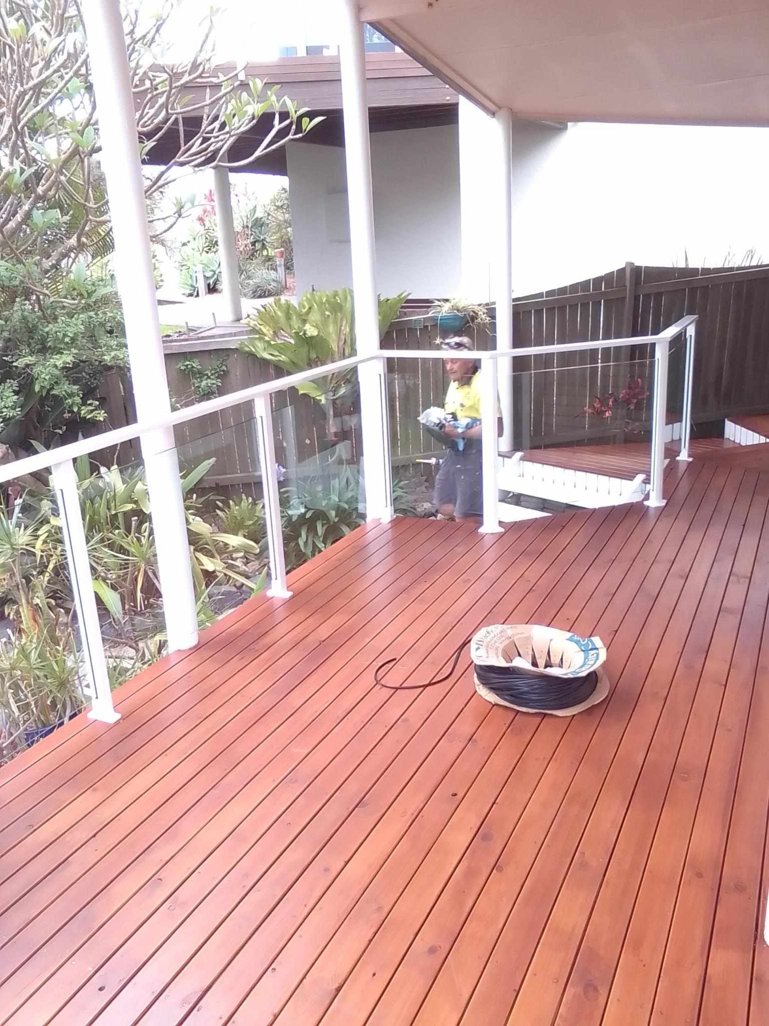 A wooden deck with a white railing and a bowl on the floor — Fabricator In Coffs Harbour, NSW