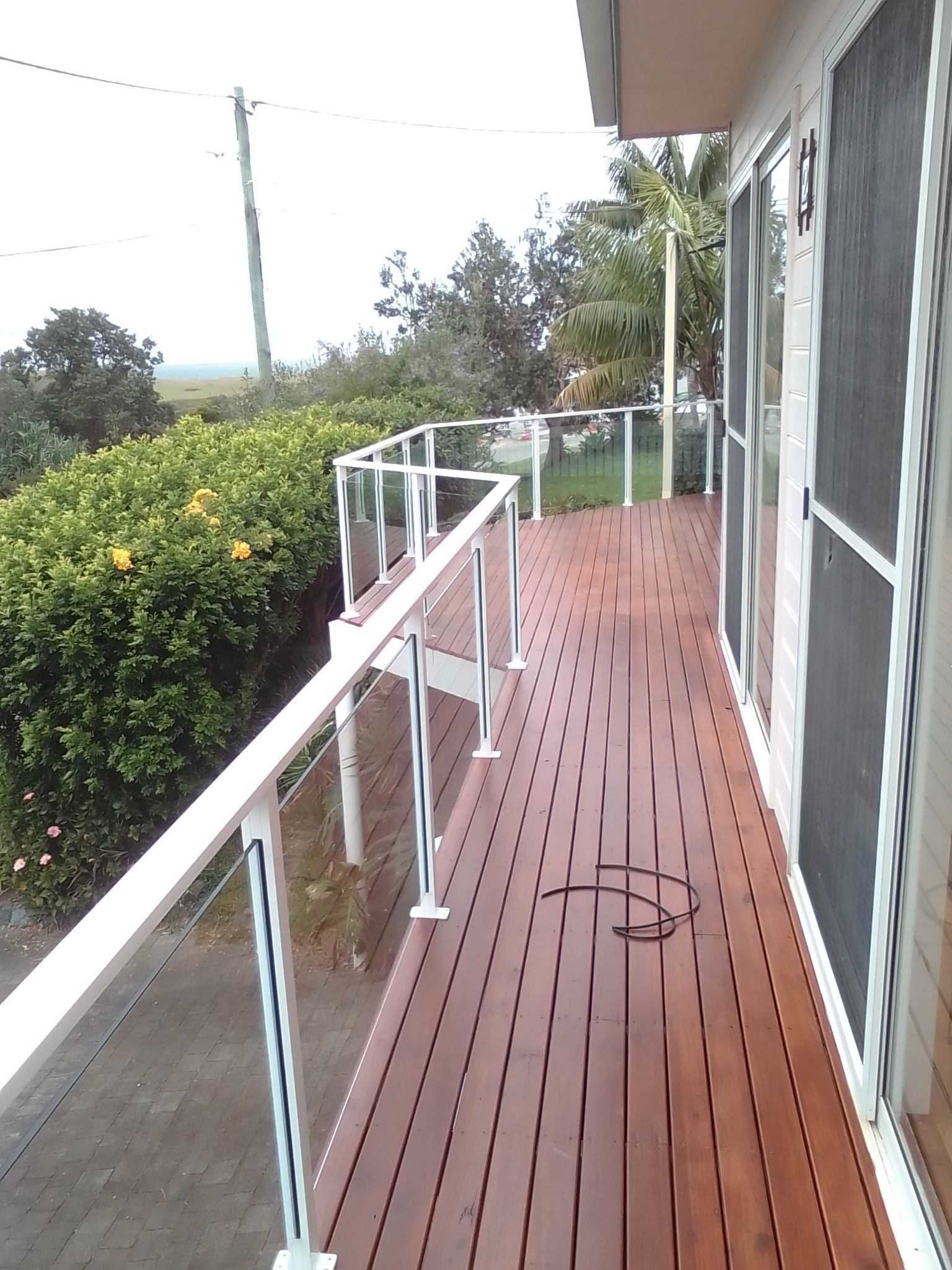 A wooden deck with a white railing and sliding screen doors — Fabricator In Coffs Harbour, NSW