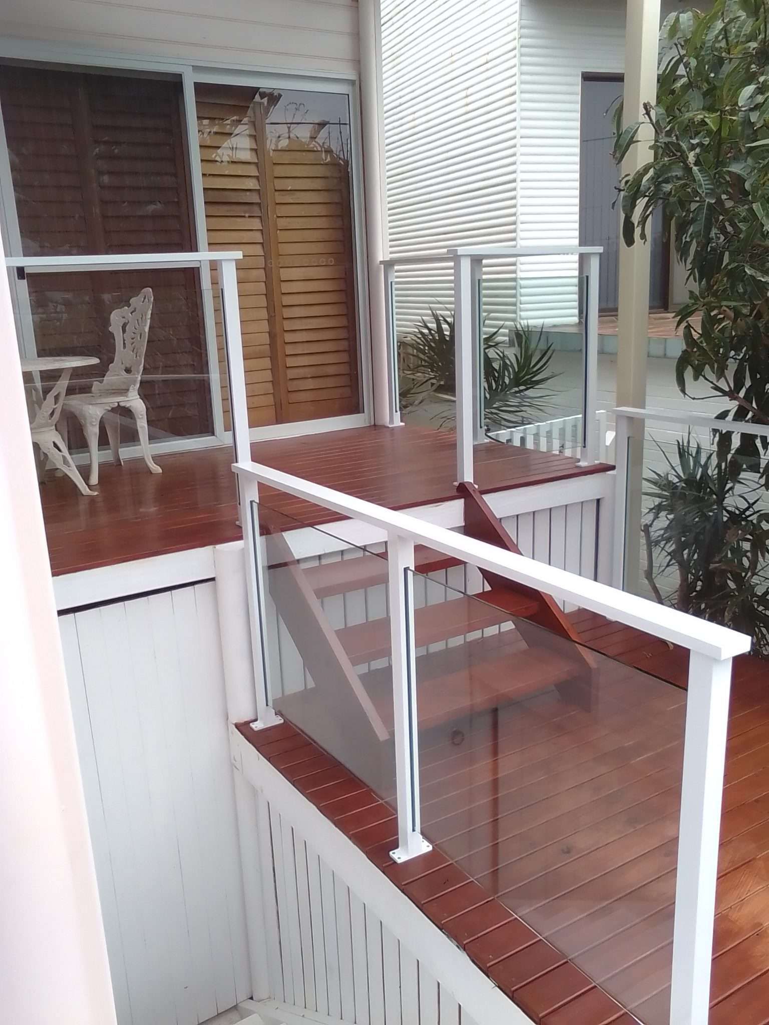 A wooden deck with stairs and a glass railing — Fabricator In Coffs Harbour, NSW