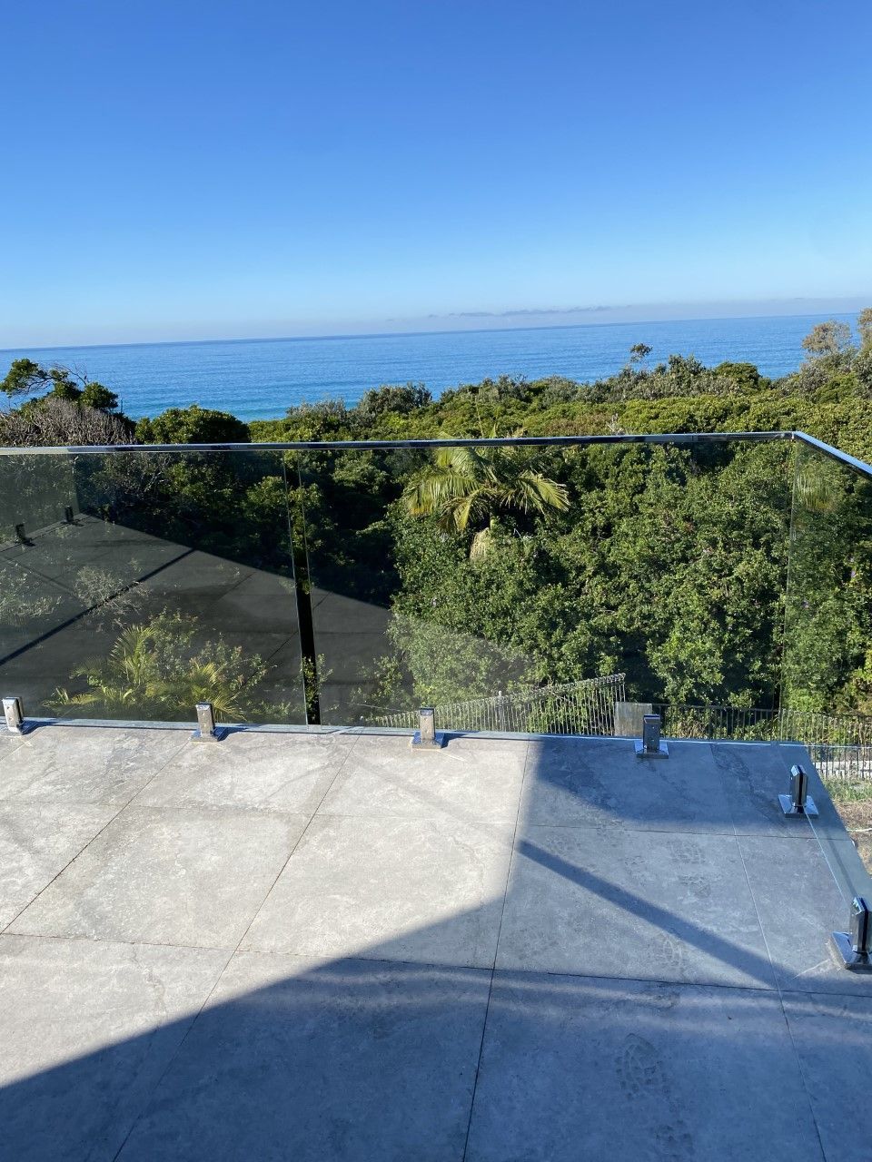 A balcony with a glass railing overlooking the ocean — Fabricator In Coffs Harbour, NSW