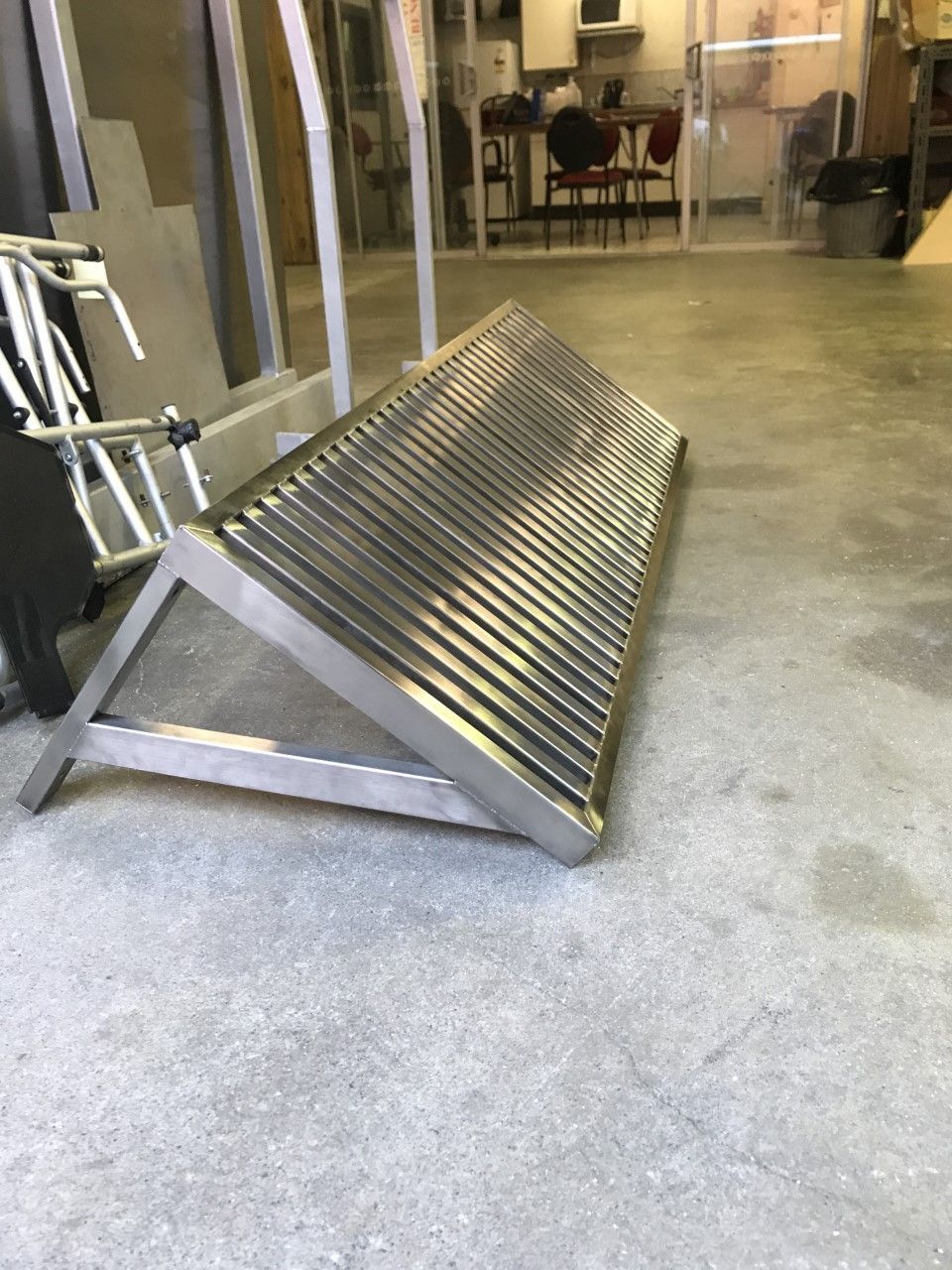 A stainless steel bench is sitting on the floor in a room — Fabricator In Coffs Harbour, NSW