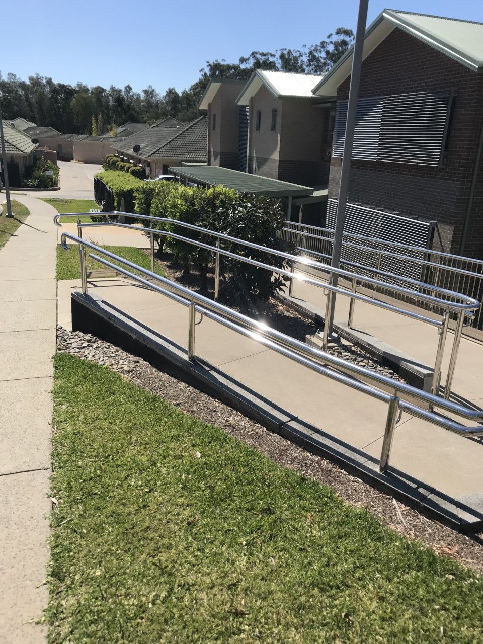 A ramp with a stainless steel railing leading to a house — Fabricator In Coffs Harbour, NSW