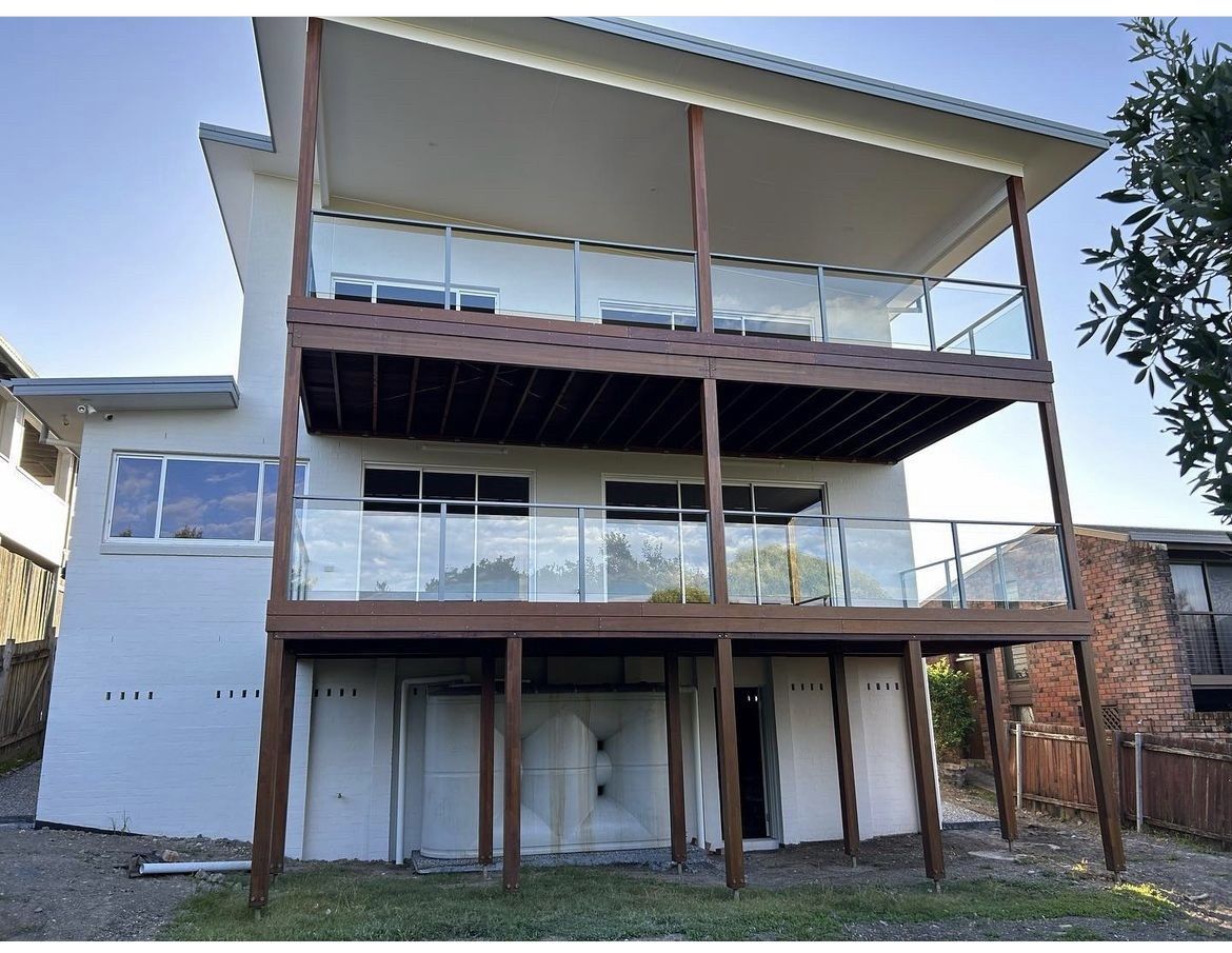 A white house with a wooden deck and balconies — Fabricator In Coffs Harbour, NSW