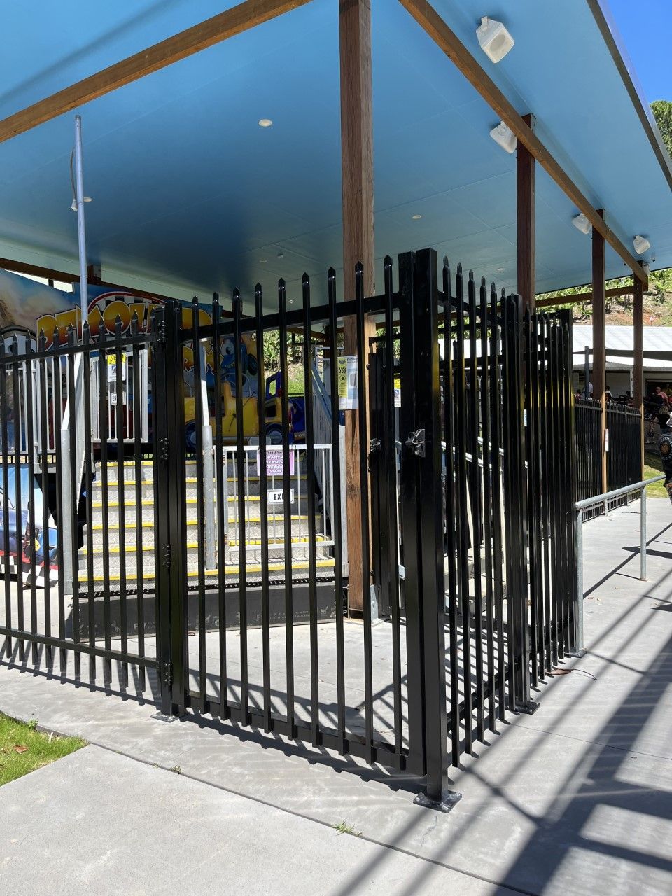 A black fence with a blue roof behind it — Fabricator In Coffs Harbour, NSW