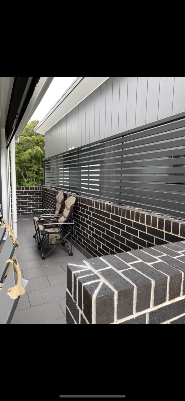 A balcony with a brick wall and chairs on it — Fabricator In Coffs Harbour, NSW