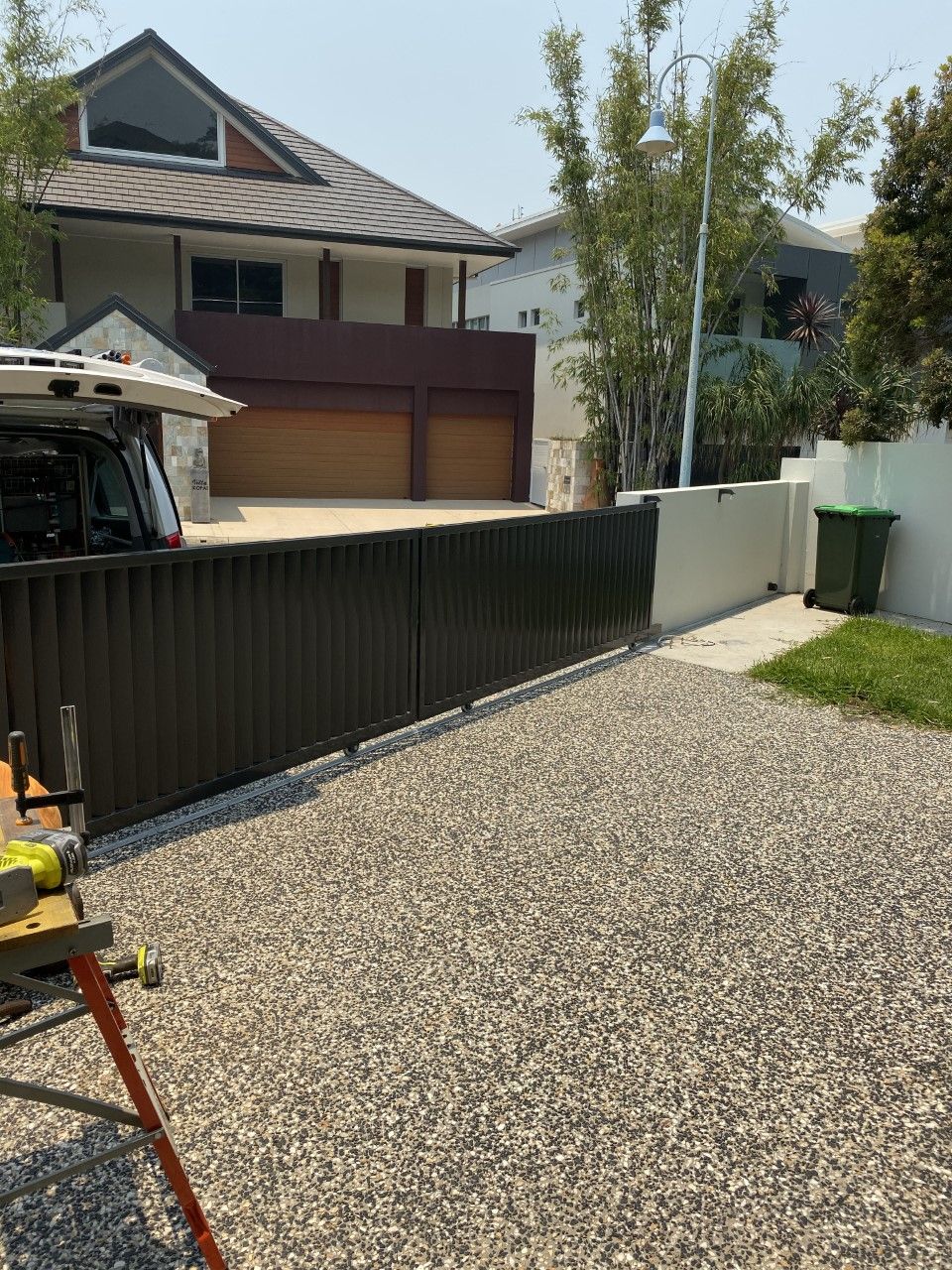 A car is parked in front of a house next to a gravel driveway — Fabricator In Coffs Harbour, NSW