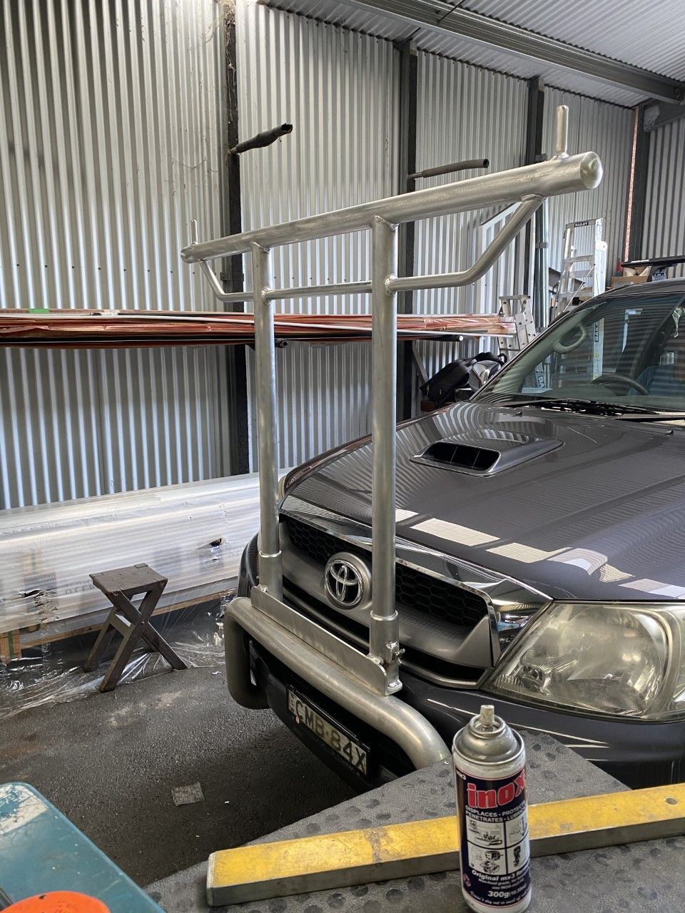 A car is parked in a garage next to a can of spray paint — Fabricator In Coffs Harbour, NSW
