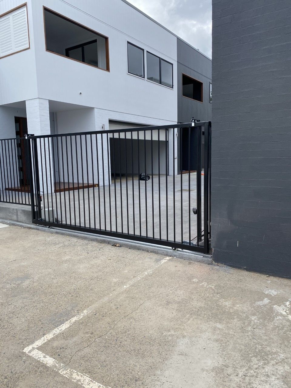 A white building with a black fence in front of it — Fabricator In Coffs Harbour, NSW