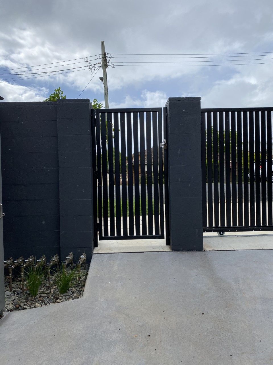 A black fence with a concrete walkway leading to it — Fabricator In Coffs Harbour, NSW