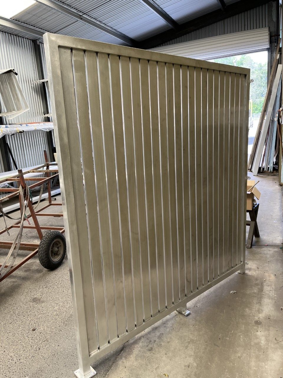 A metal fence is sitting on the floor in a warehouse — Fabricator In Coffs Harbour, NSW