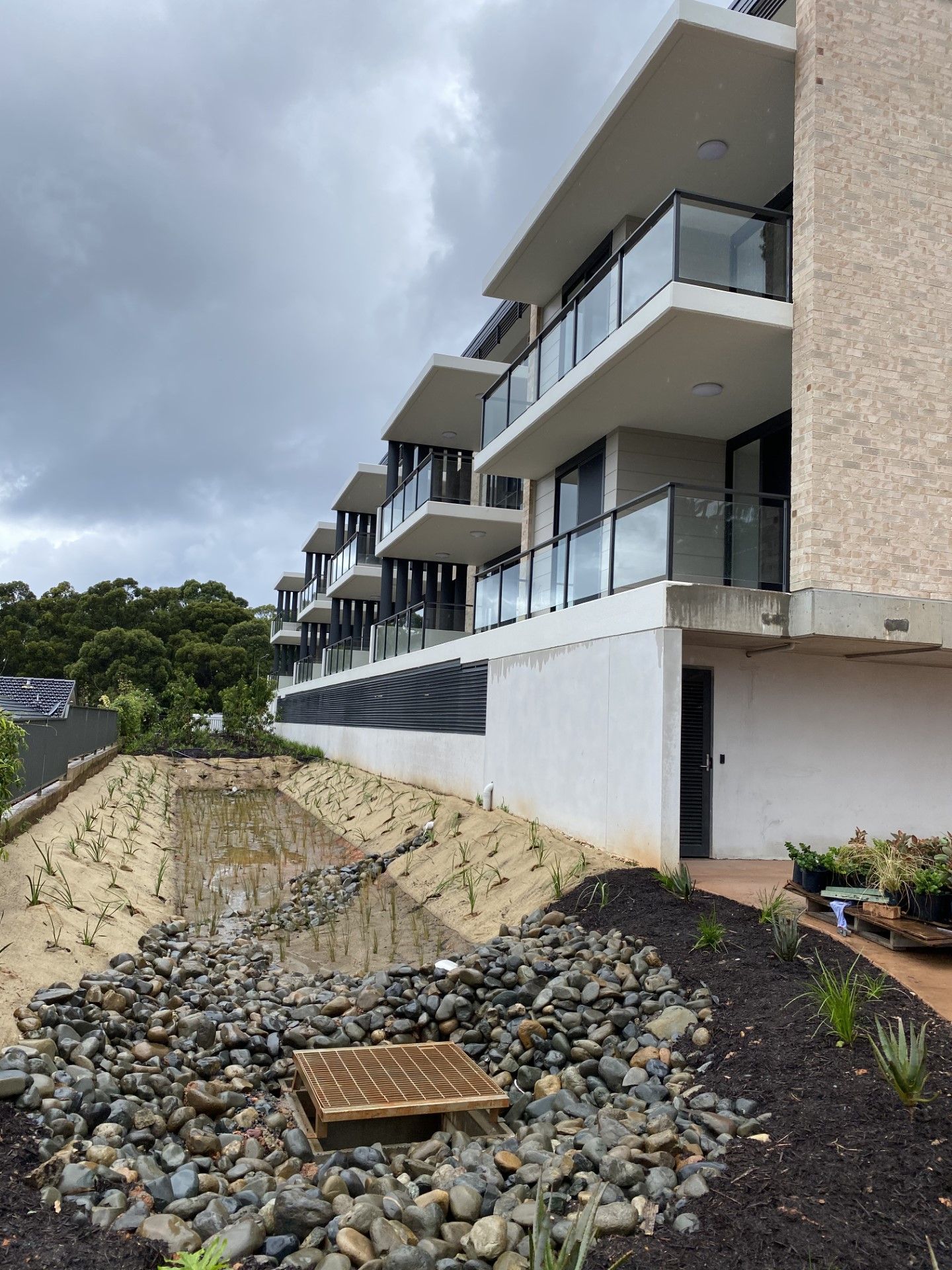 A building with a lot of windows and balconies is surrounded by rocks and dirt — Fabricator In Coffs Harbour, NSW