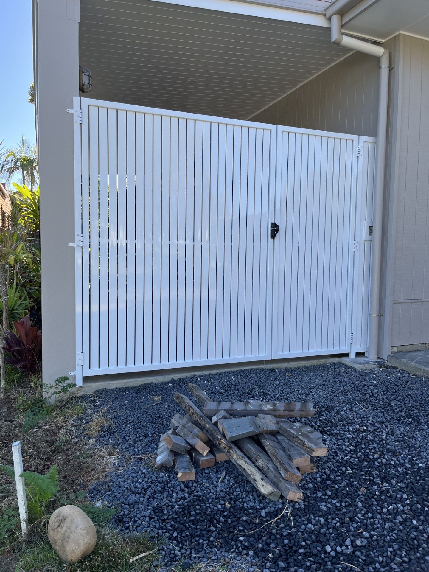 A white gate is sitting next to a pile of wood — Fabricator In Coffs Harbour, NSW