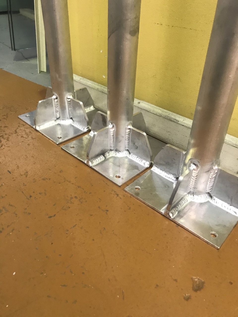A row of metal poles sitting on top of a wooden table — Fabricator In Coffs Harbour, NSW
