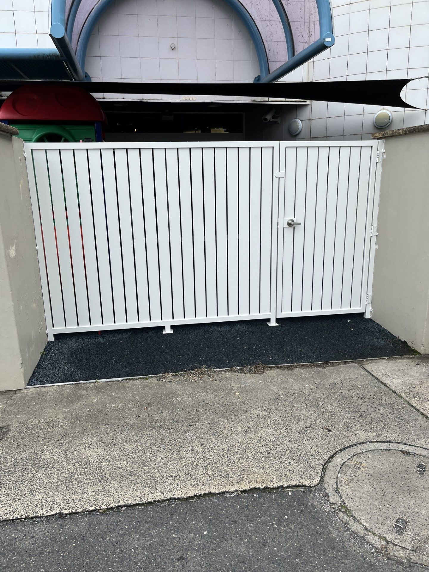 A white gate is sitting on a sidewalk next to a building — Fabricator In Coffs Harbour, NSW