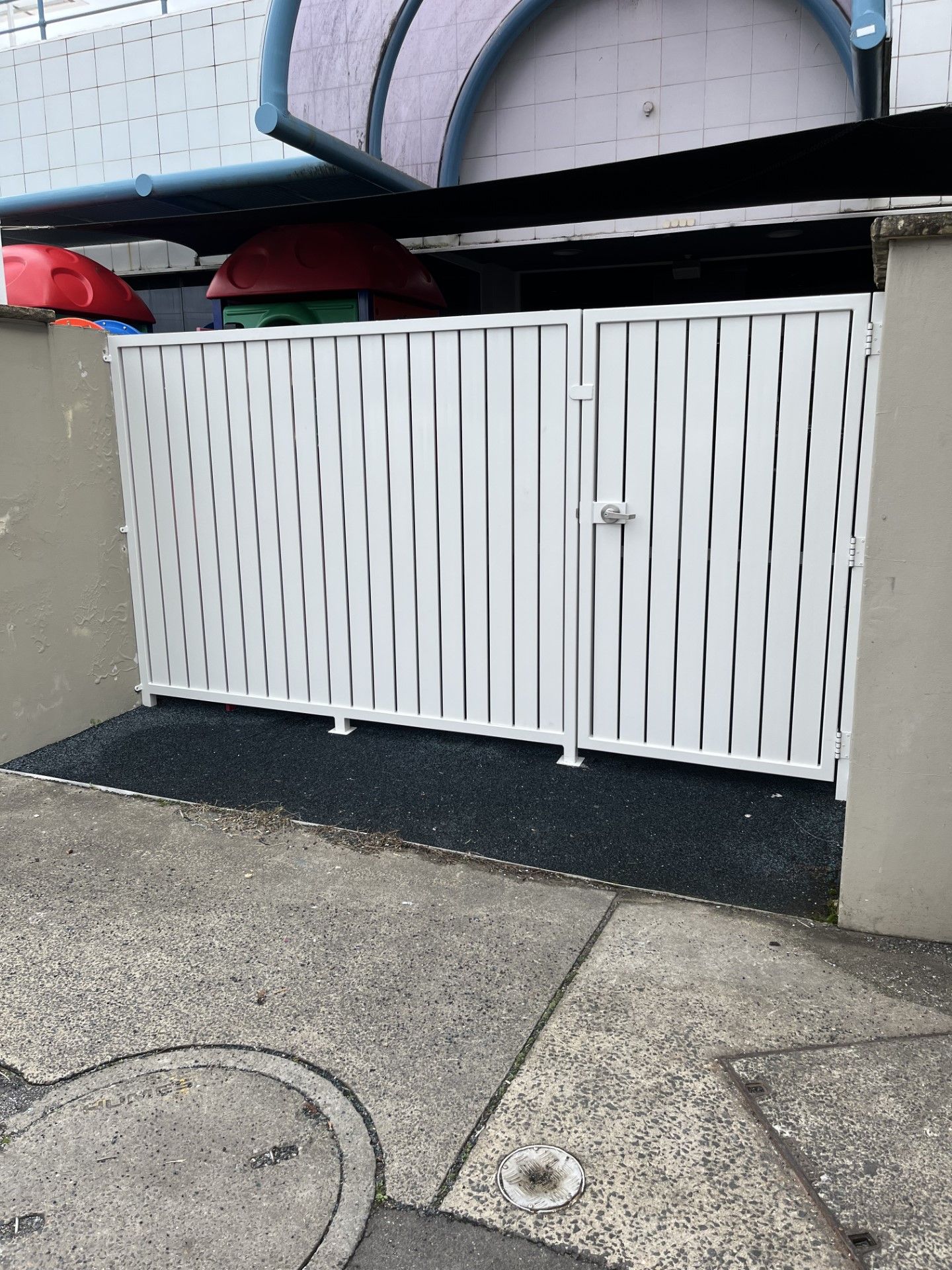 A white fence is sitting on the sidewalk in front of a building — Fabricator In Coffs Harbour, NSW