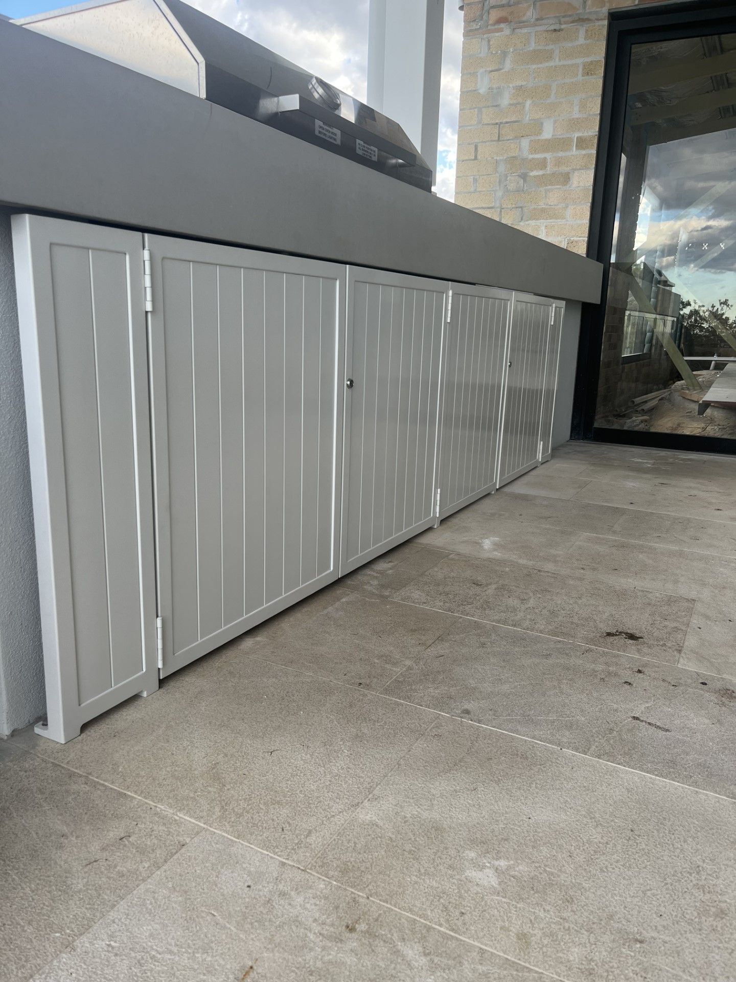 A white cabinet is sitting on a tiled floor next to a window — Fabricator In Coffs Harbour, NSW