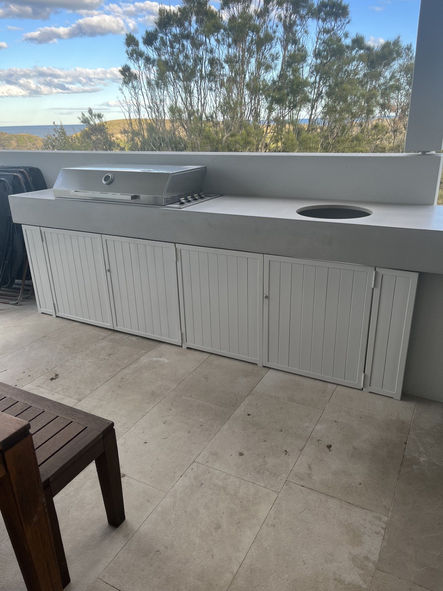 There is a table and a bench on the patio with a view of the ocean — Fabricator In Coffs Harbour, NSW