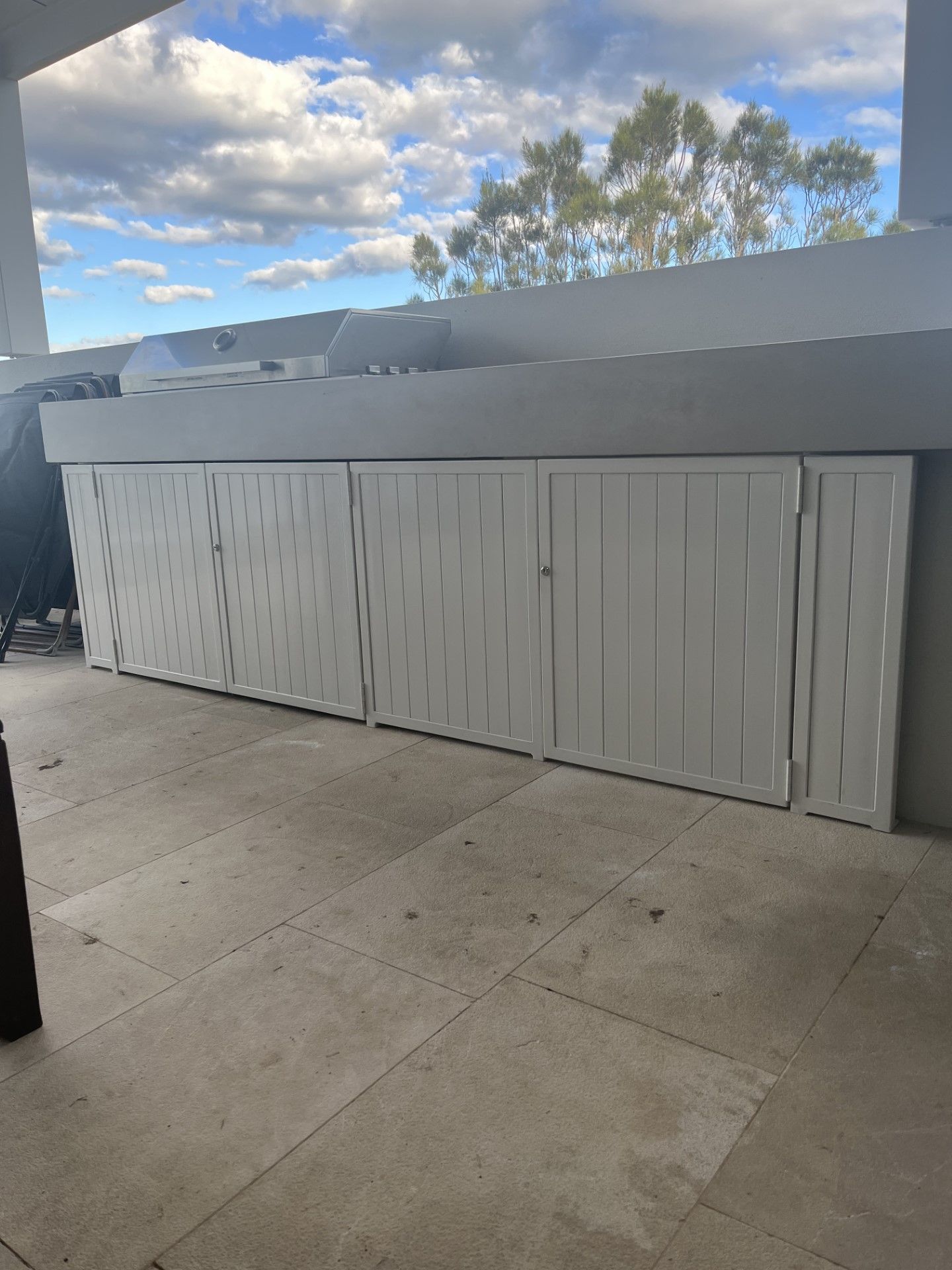 A white fence is sitting on top of a tiled floor on a patio — Fabricator In Coffs Harbour, NSW