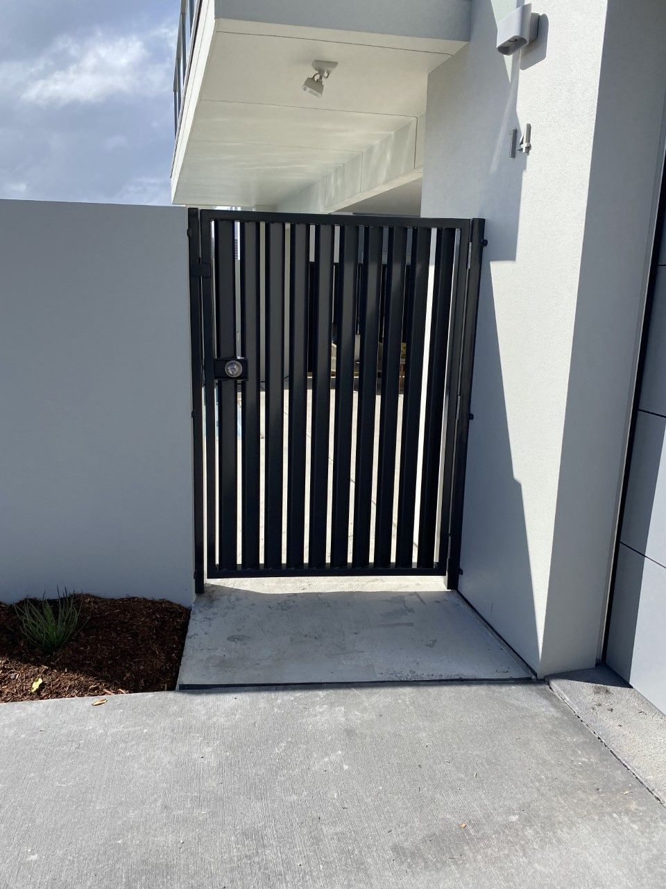 A black gate is leading to a white building — Fabricator In Coffs Harbour, NSW