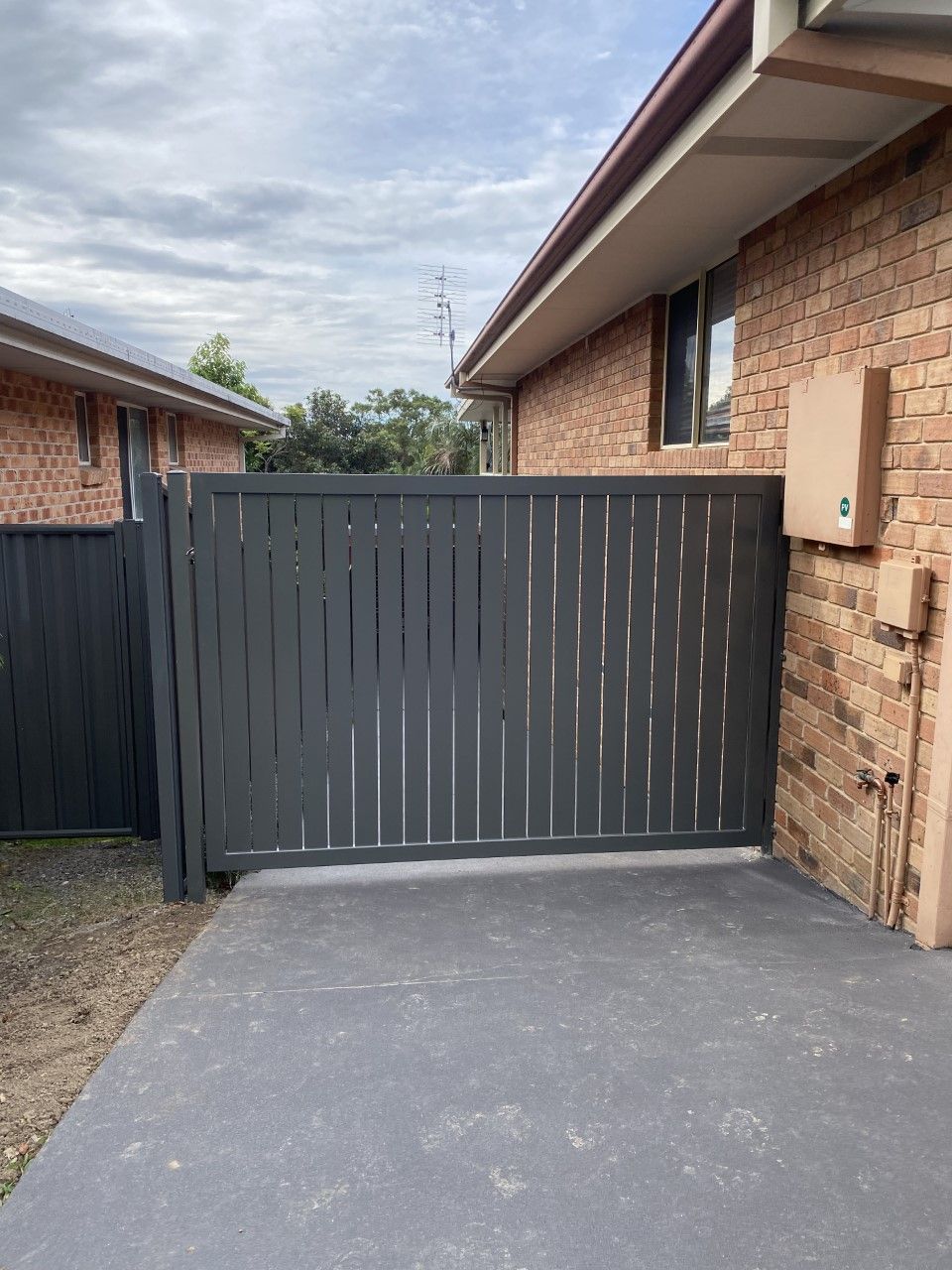 A brick house with a sliding gate in front of it — Fabricator In Coffs Harbour, NSW