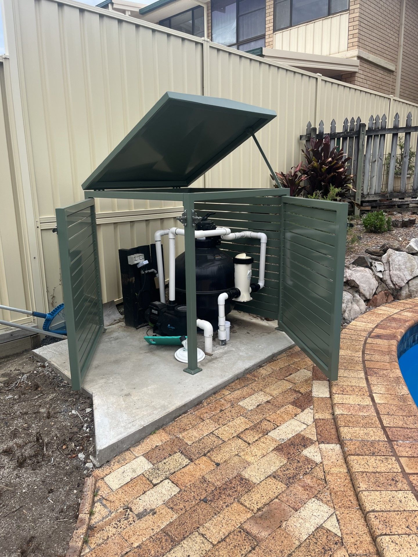 A swimming pool filter is sitting in a shed next to a fence — Fabricator In Coffs Harbour, NSW