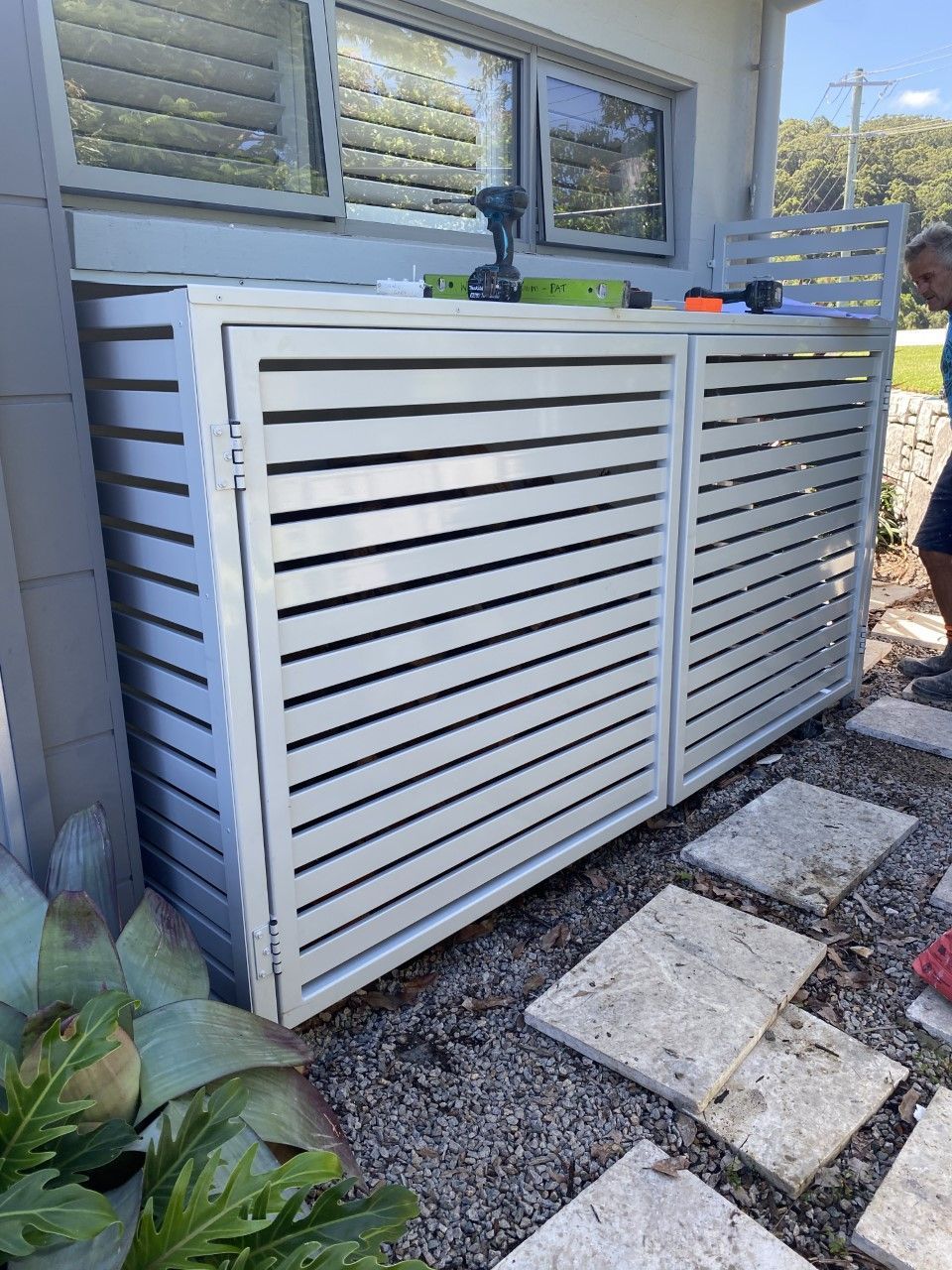 A man is standing next to a white fence in front of a house — Fabricator In Coffs Harbour, NSW