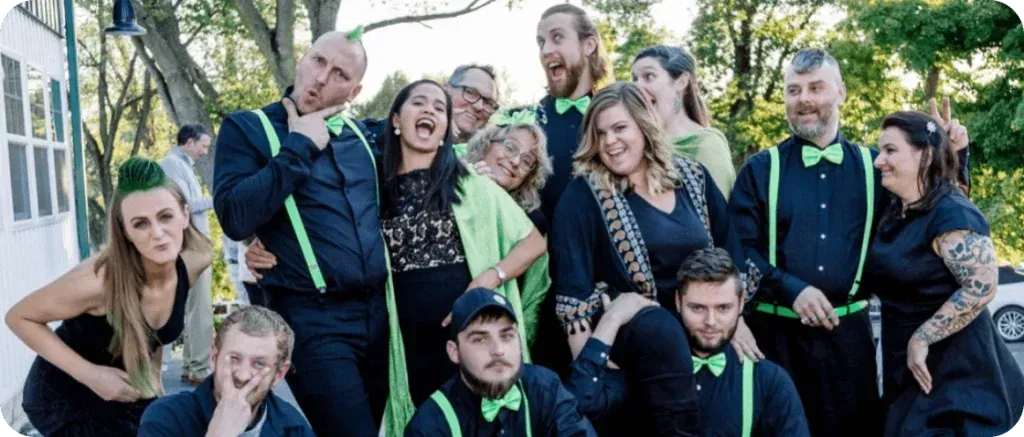 Zima team in black outfits with neon green accents posing outdoors and smiling