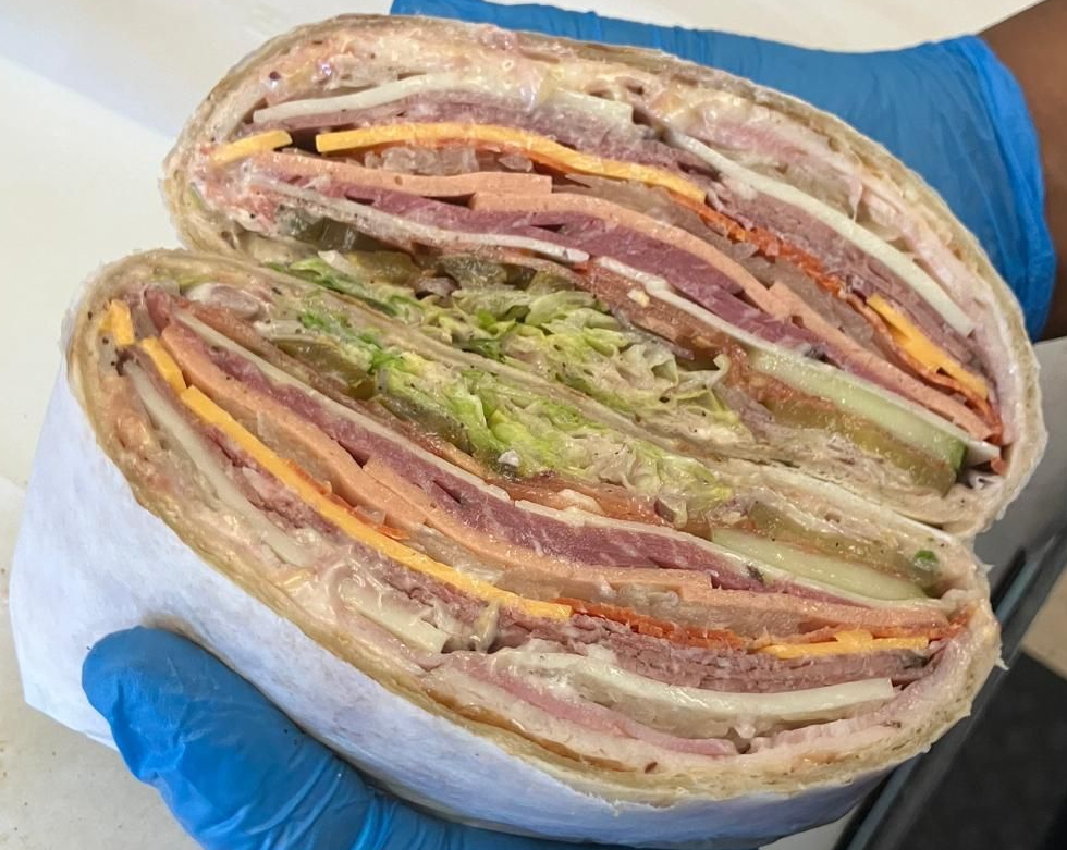 A hot dog is sitting on a wooden cutting board.