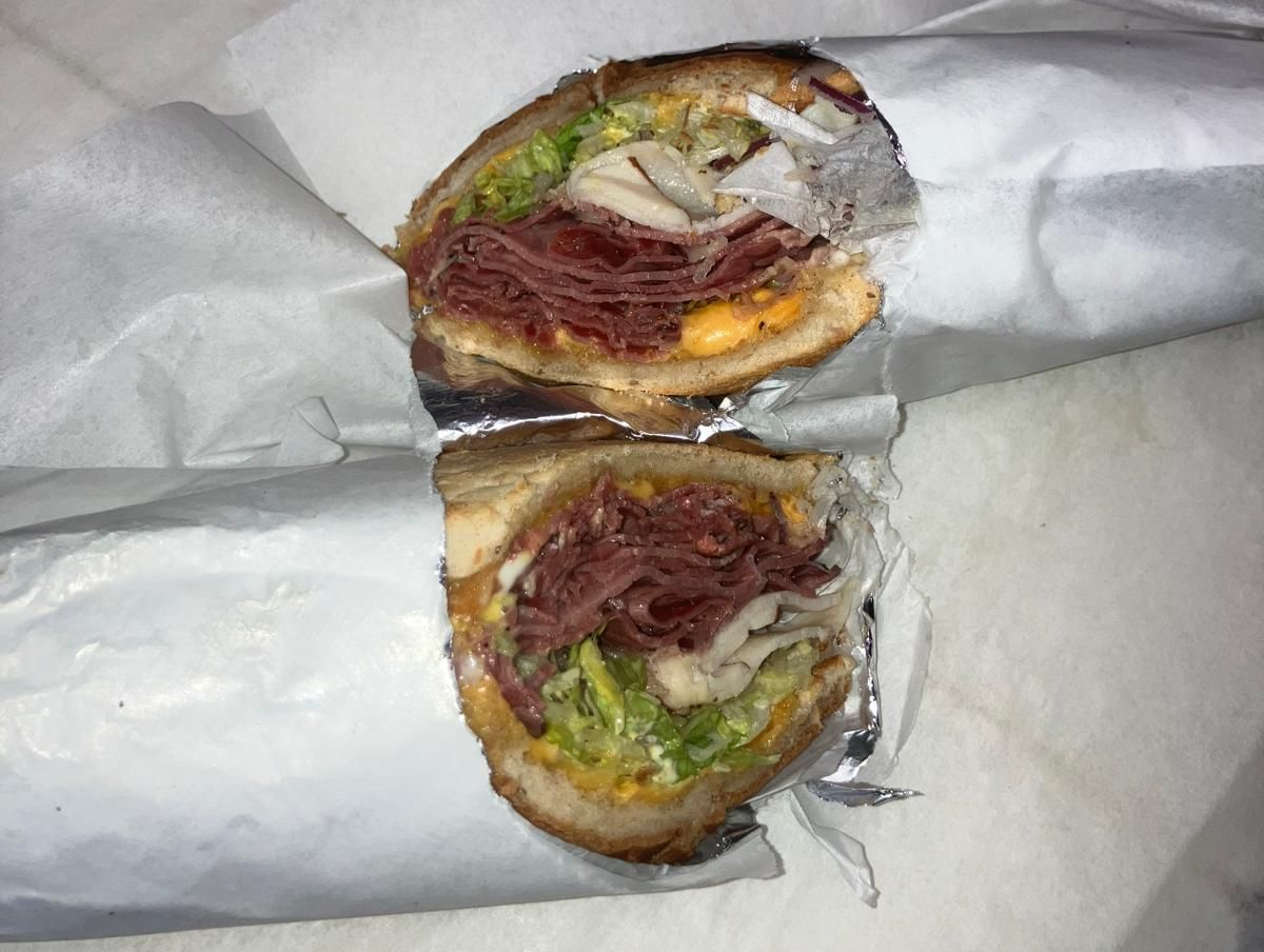 Two sub sandwiches are stacked on top of each other on a plate.