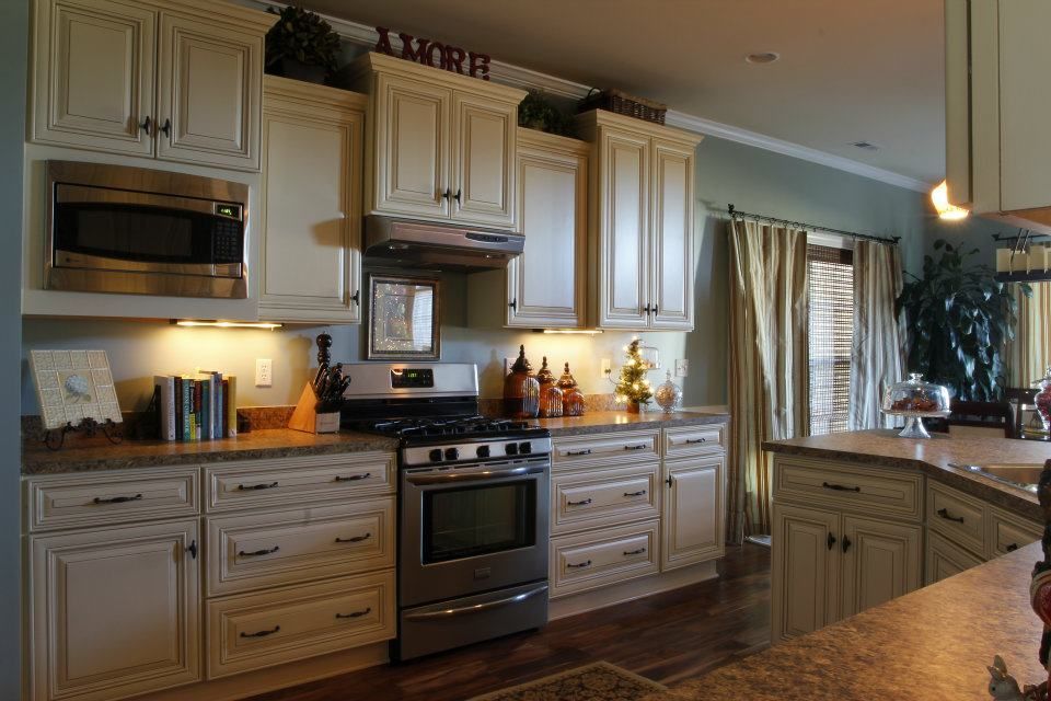 Kitchen with cream cabinets, stainless steel appliances, and dark countertops.