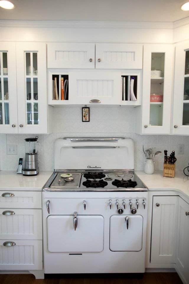 White kitchen with a vintage stove, white cabinets, and countertop.