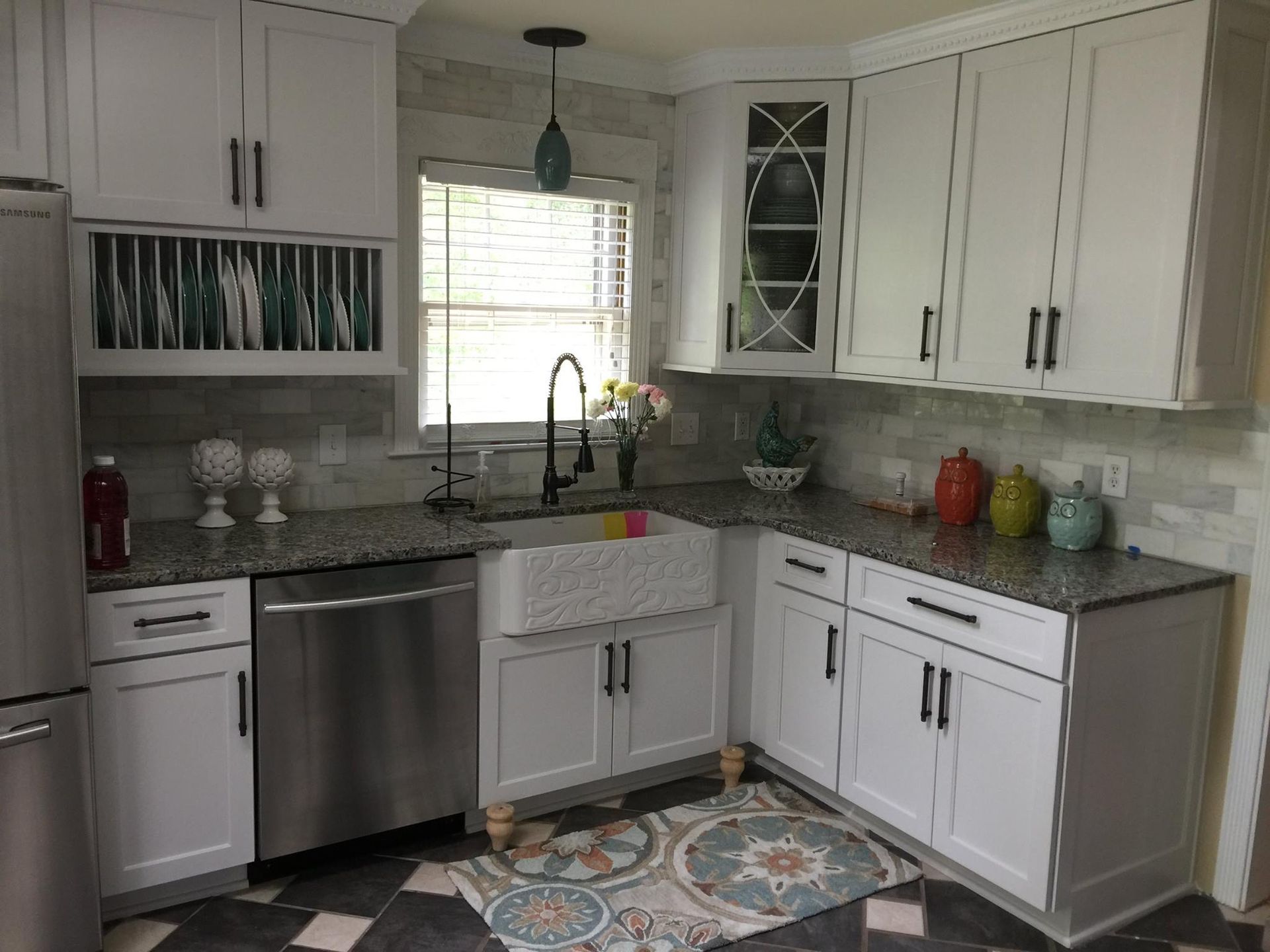 White kitchen with granite countertops, stainless steel appliances, and farmhouse sink.