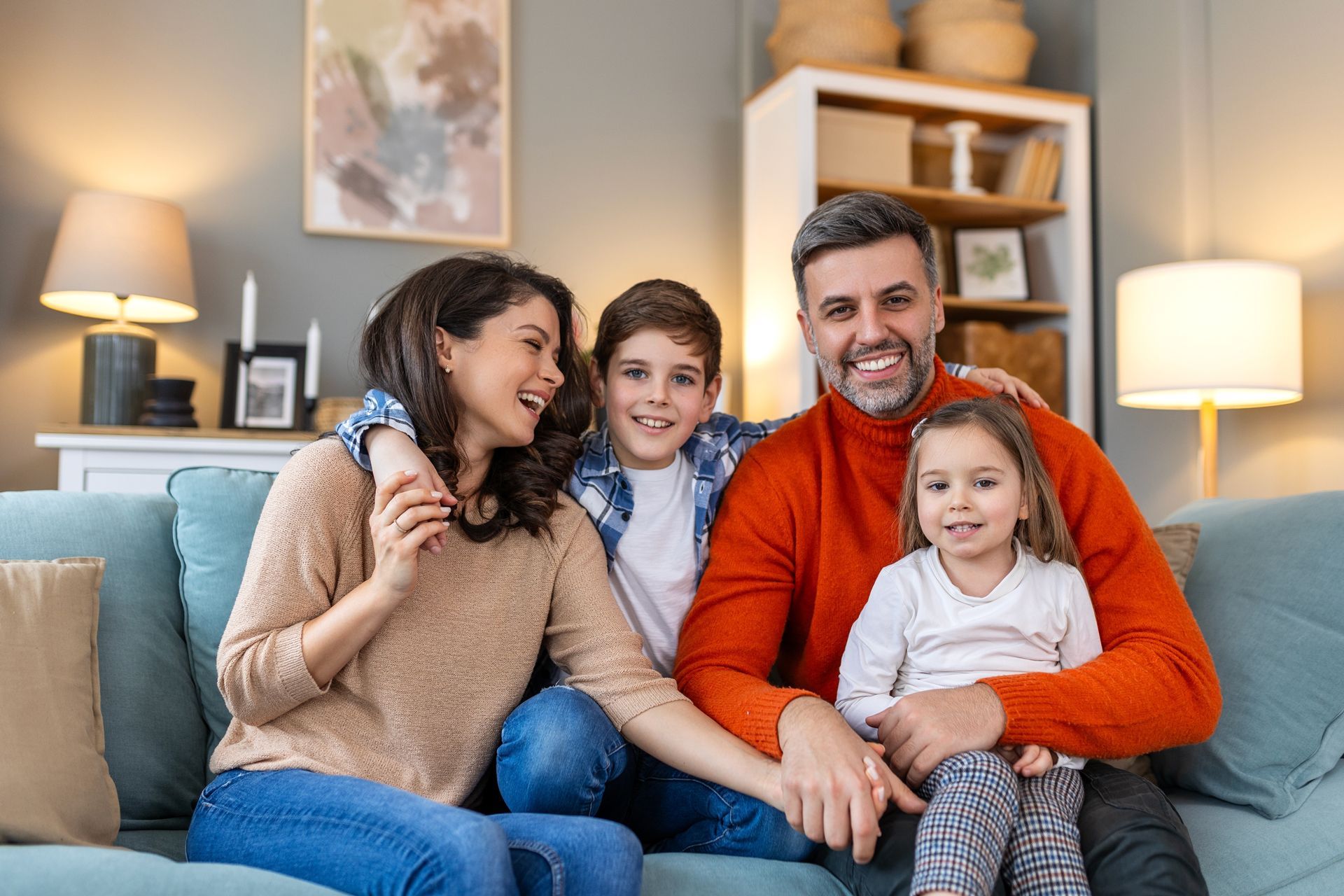 A family is sitting on a couch in a living room.