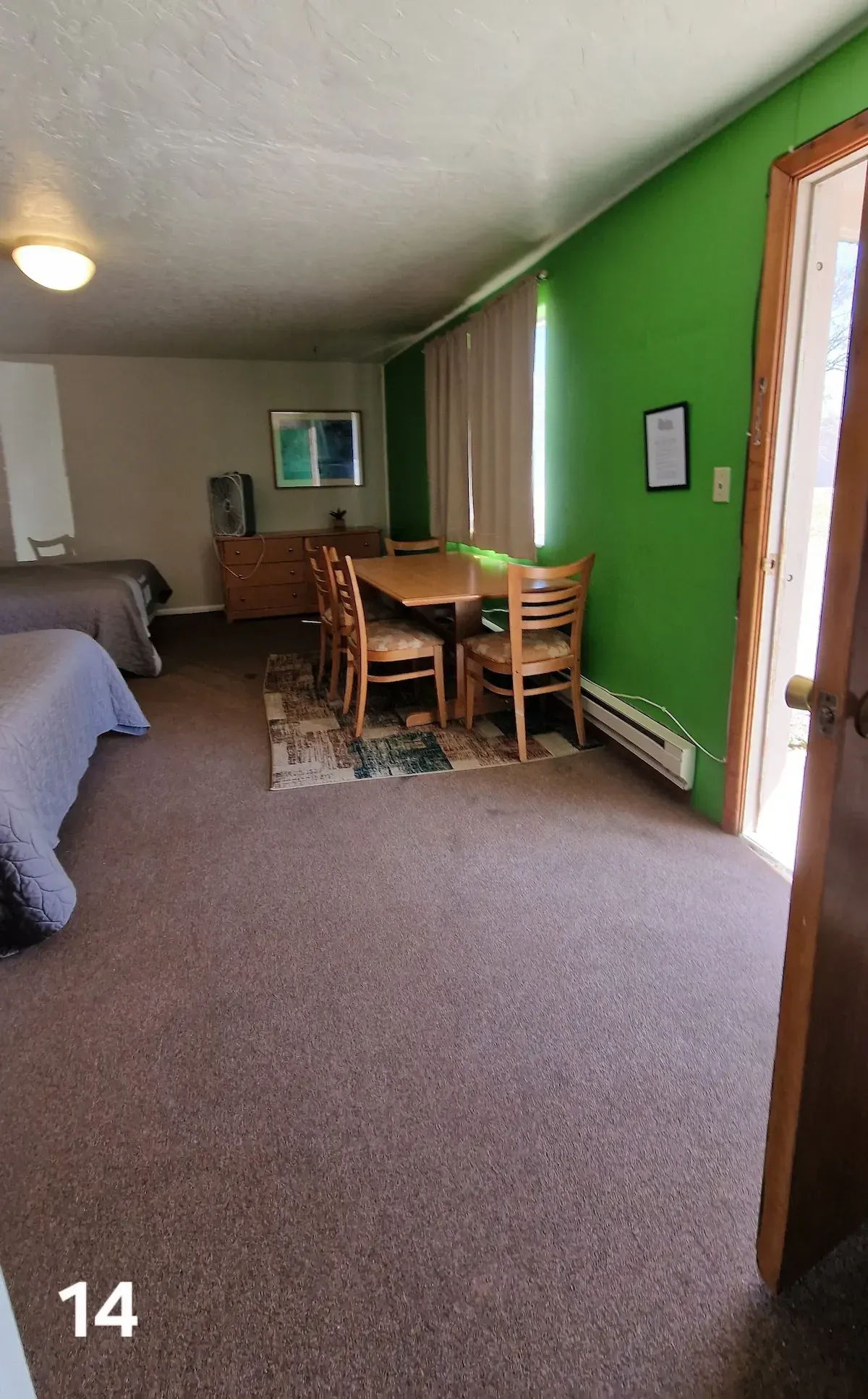 A hotel room with two beds , a table and chairs.