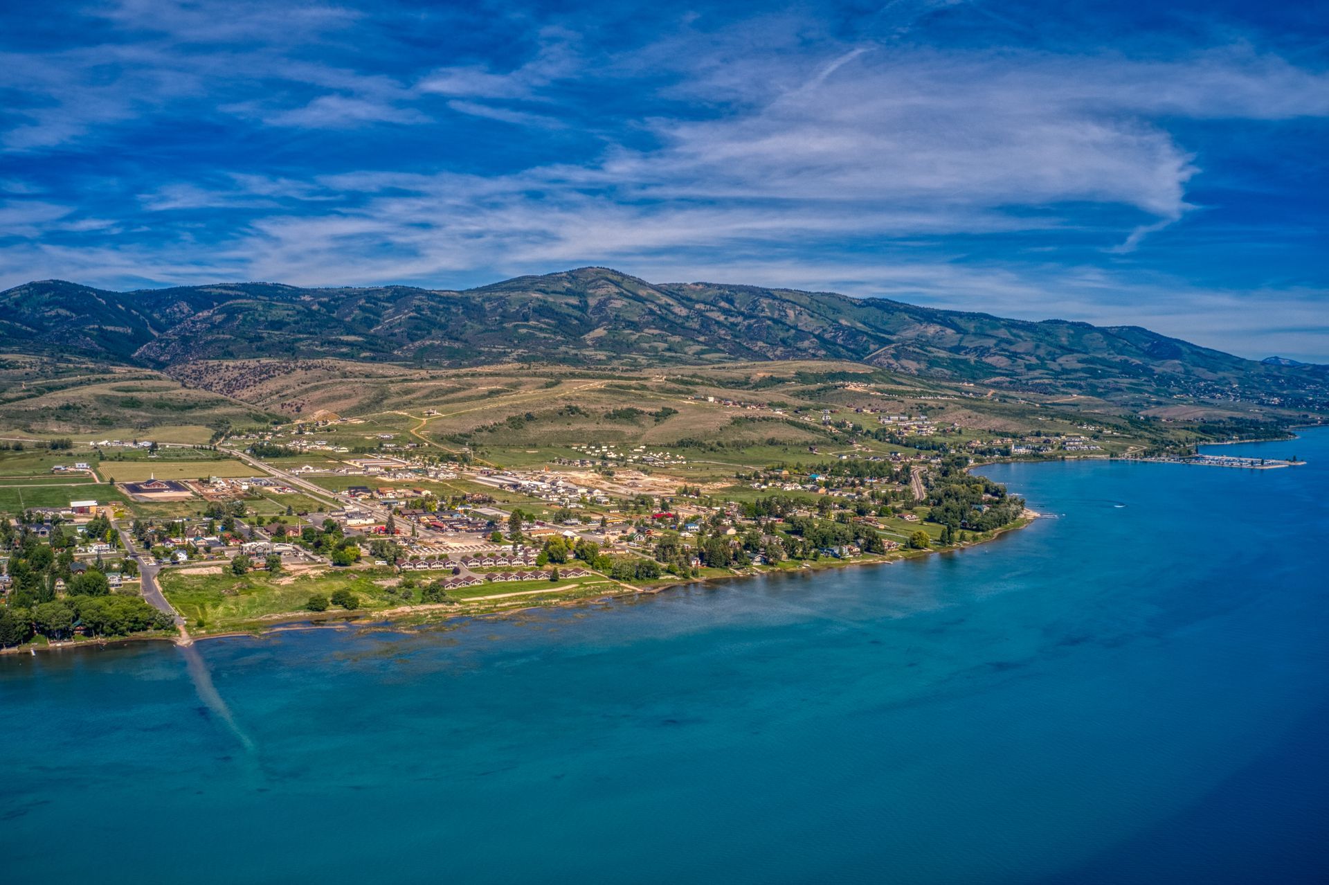 An aerial view of a lake with mountains in the background.