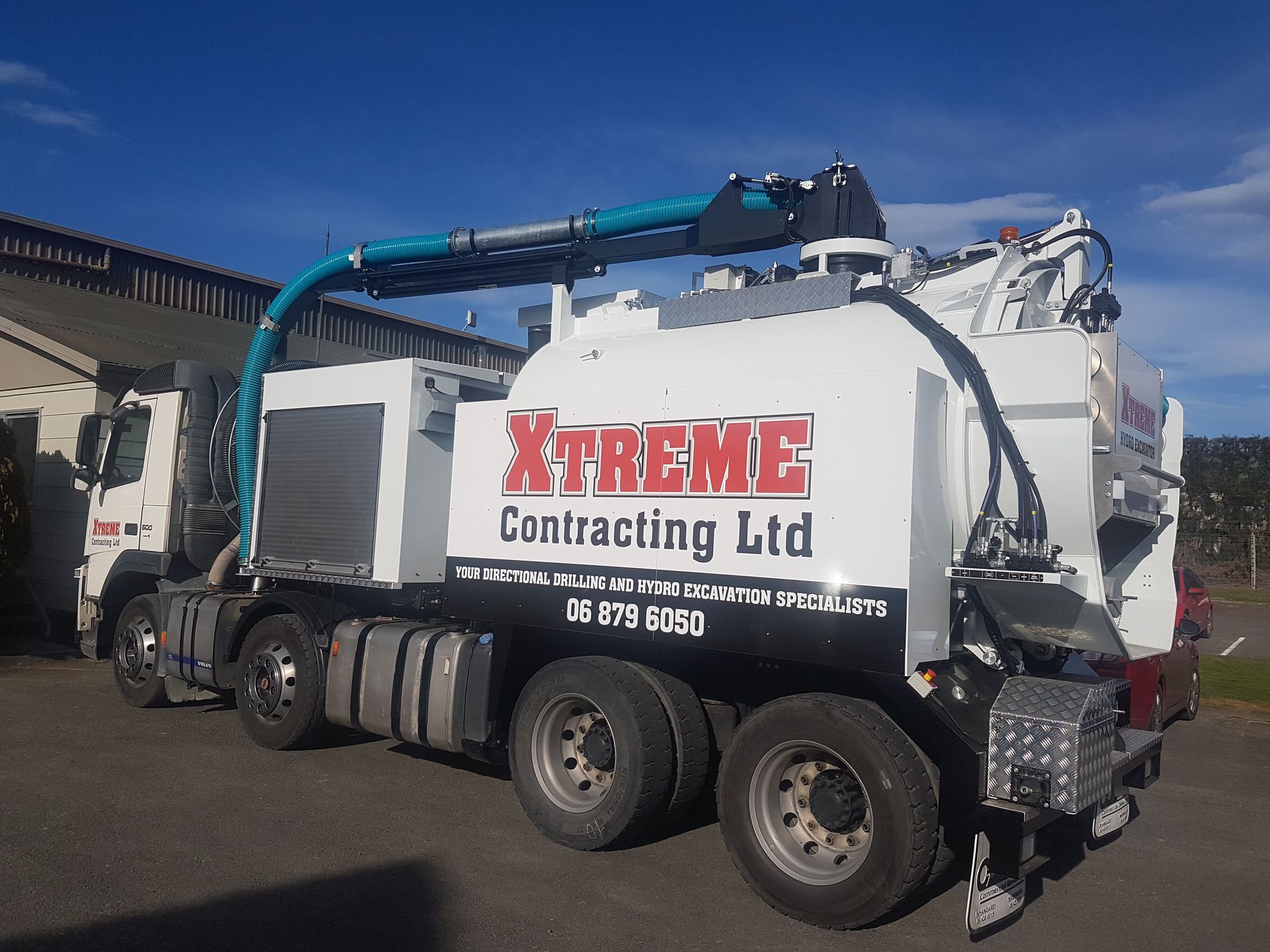 A white xtreme contracting ltd truck is parked in a parking lot.
