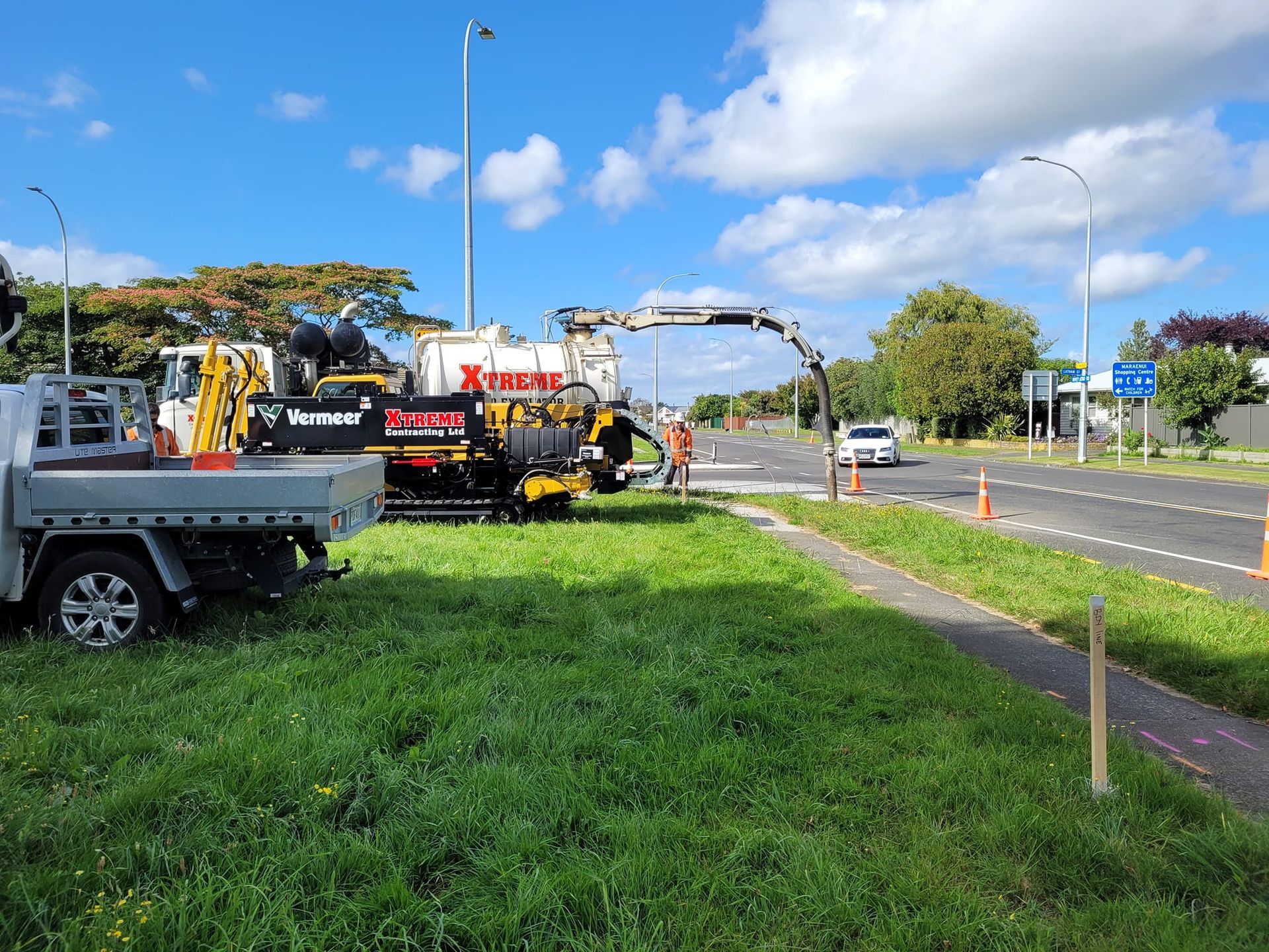 A truck is parked in the grass next to a road.