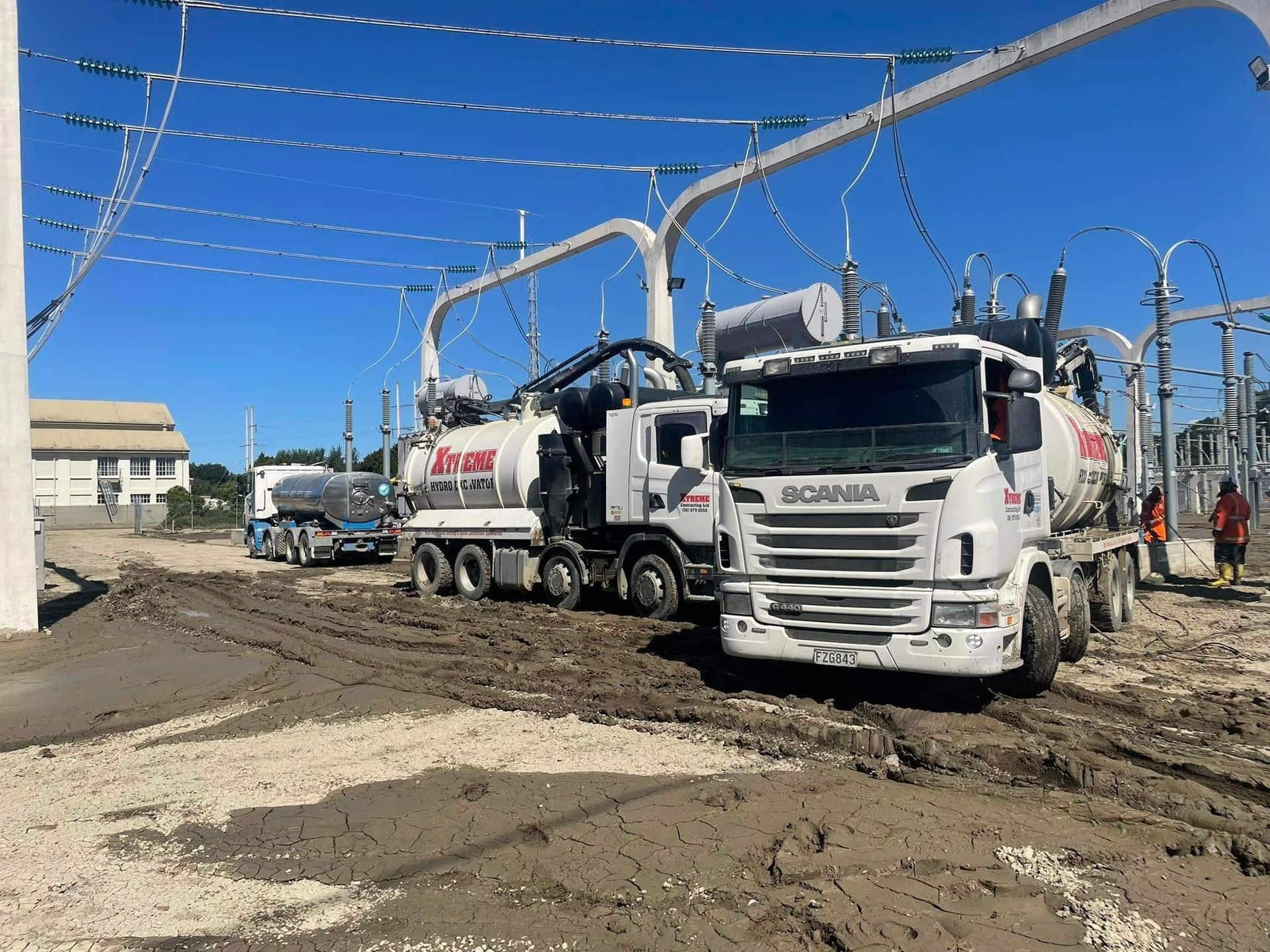 A scania truck is driving down a muddy road.